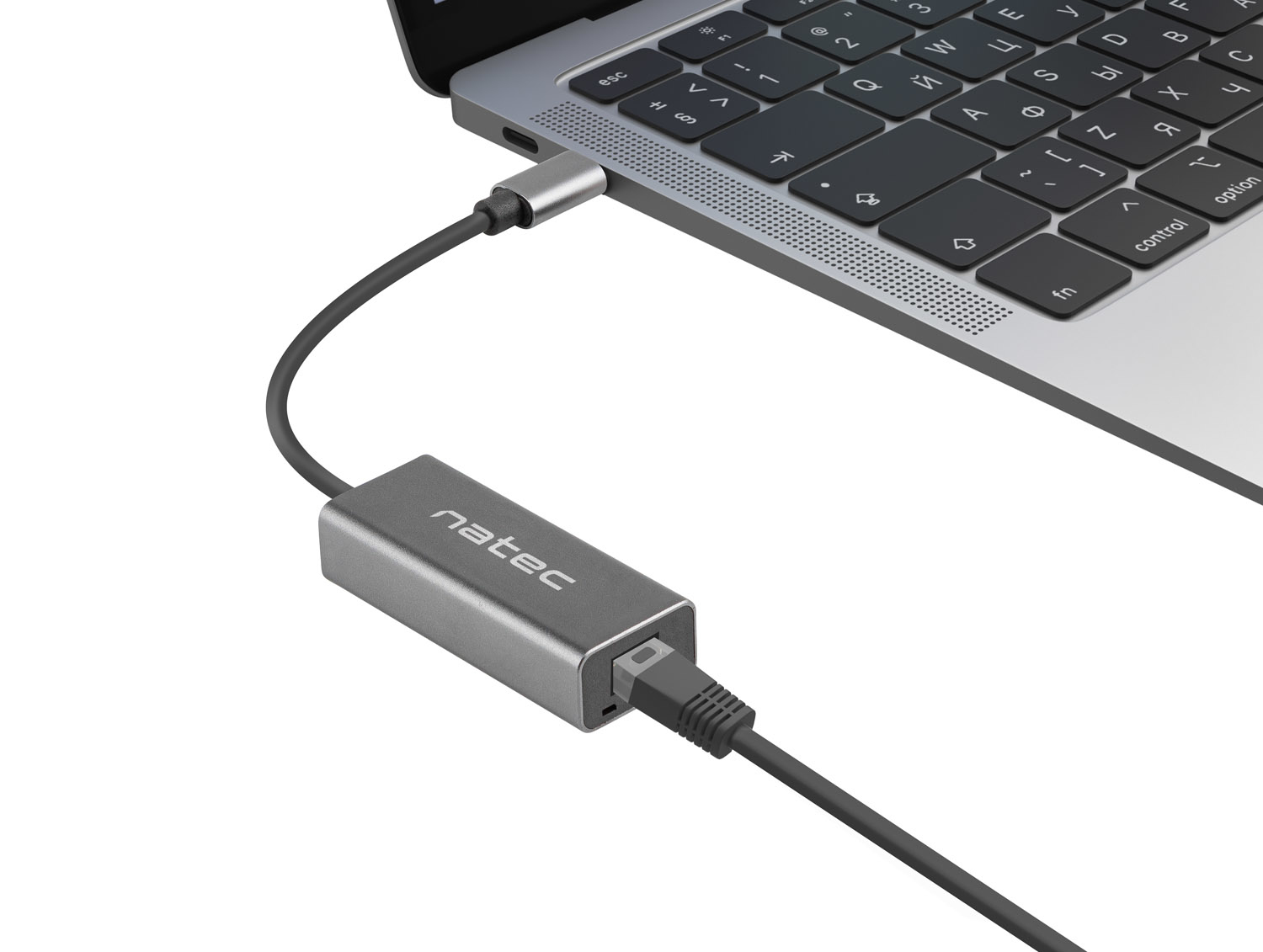 Un adaptador Natec plateado conectado a un portátil a través de USB-C, con un cable Ethernet enchufado.