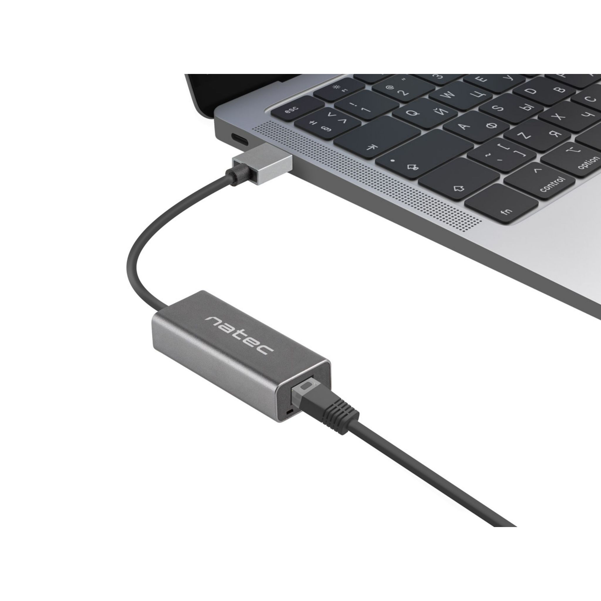 Un adattatore Natec grigio collegato a un laptop e un cavo Ethernet nero.