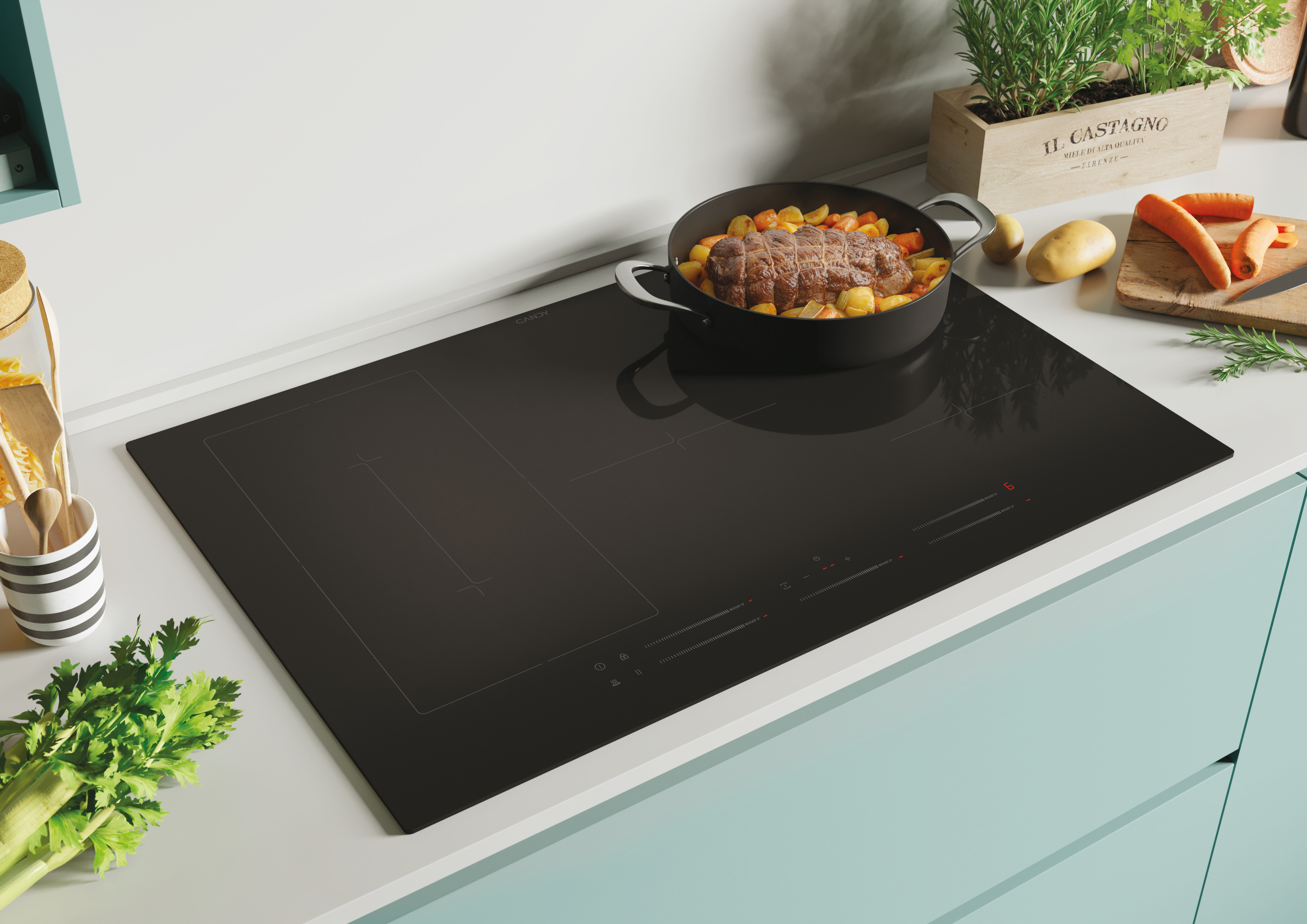 Czarna płyta indukcyjna Candy z garnkiem jedzenia. Warzywa i roślina w tle. Jasnoniebieski blat.
