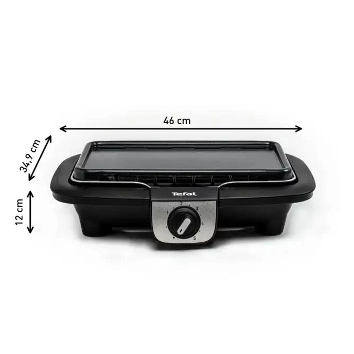 Un primo piano del bordo di un piano cottura nero su un piano di marmo, che evidenzia il contrasto dei materiali e il design elegante.