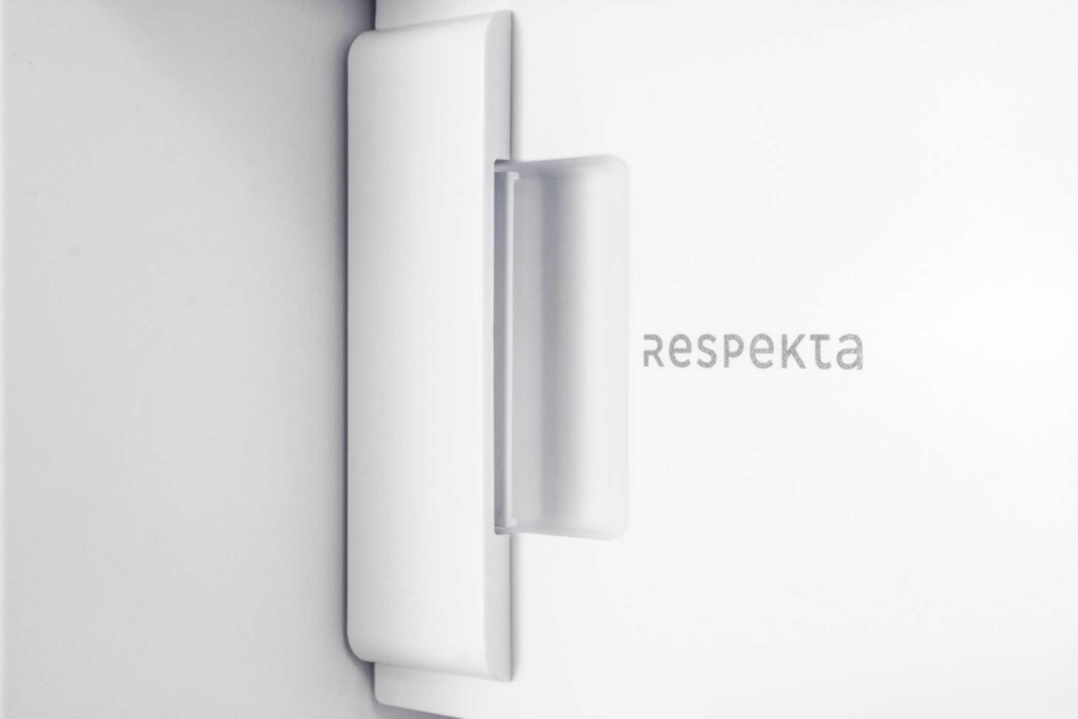 Ein weißer Türgriff mit dem Wort 'Respekta' auf der Tür.