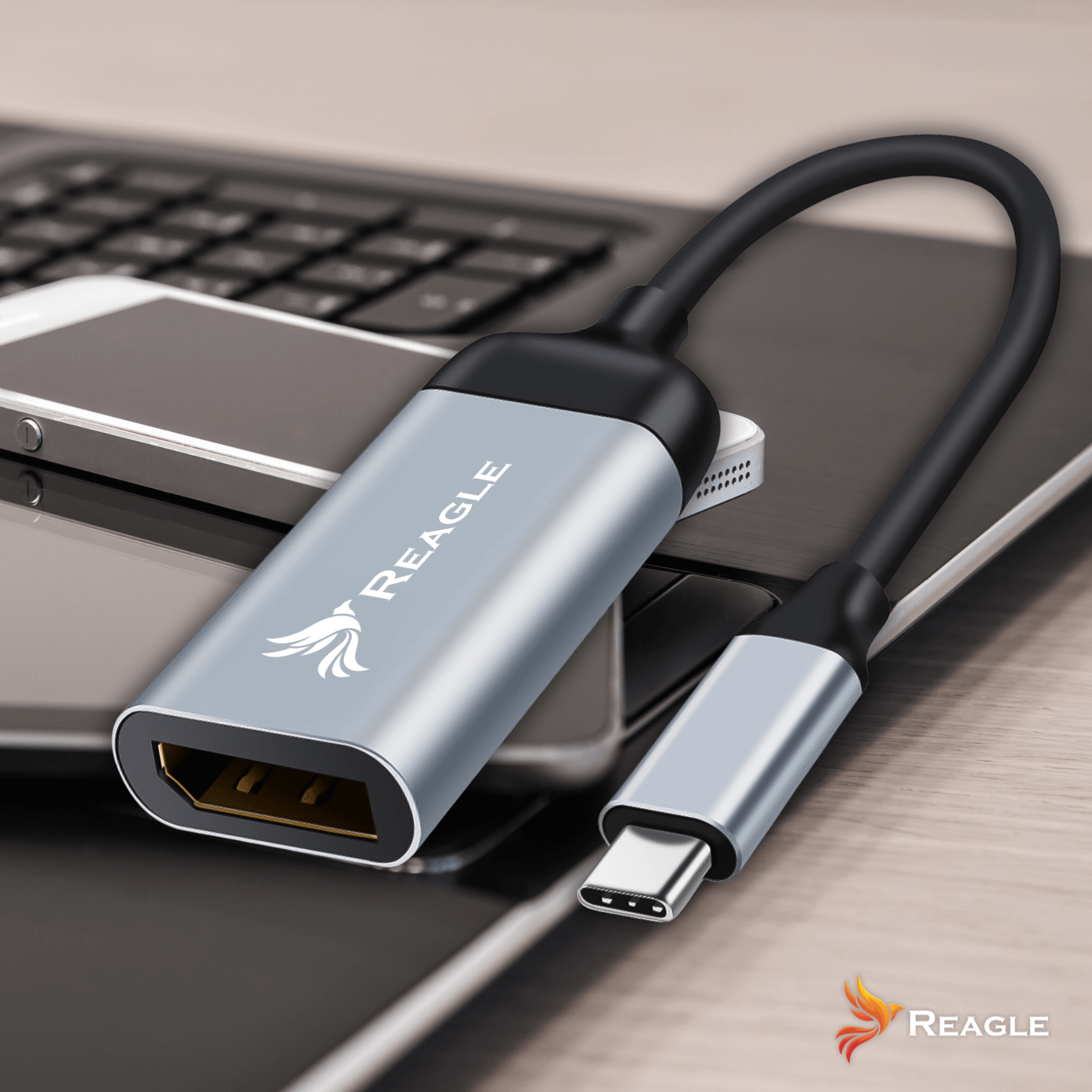 Srebrny adapter HDMI do USB-C podłączony do laptopa i smartfona.