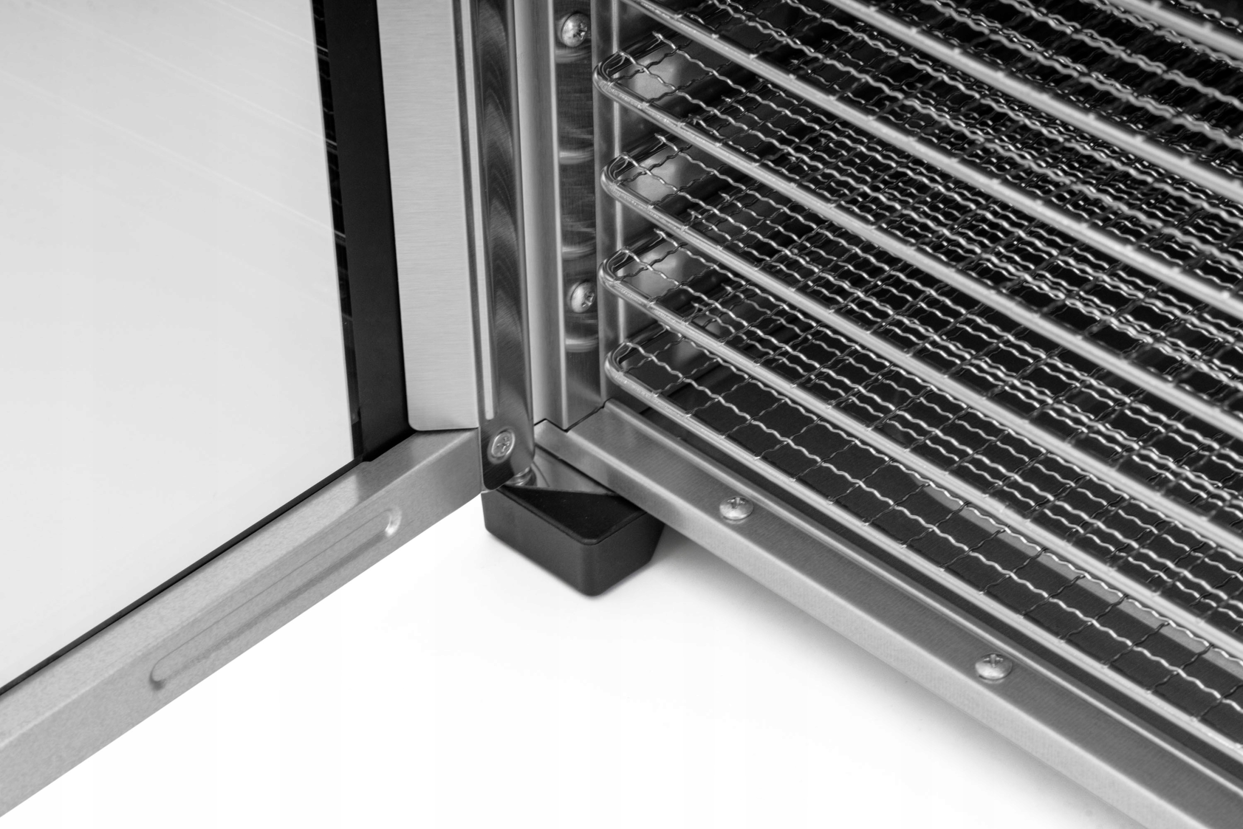 Zbliżenie rogu suszarki, pokazujące metalową ramę i półki.