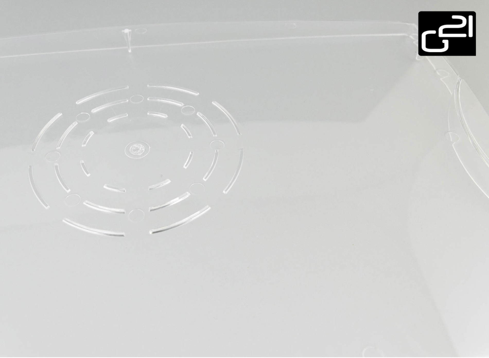 Zbliżenie przezroczystej pokrywy z wytrawionym okrągłym wzorem. Białe tło.