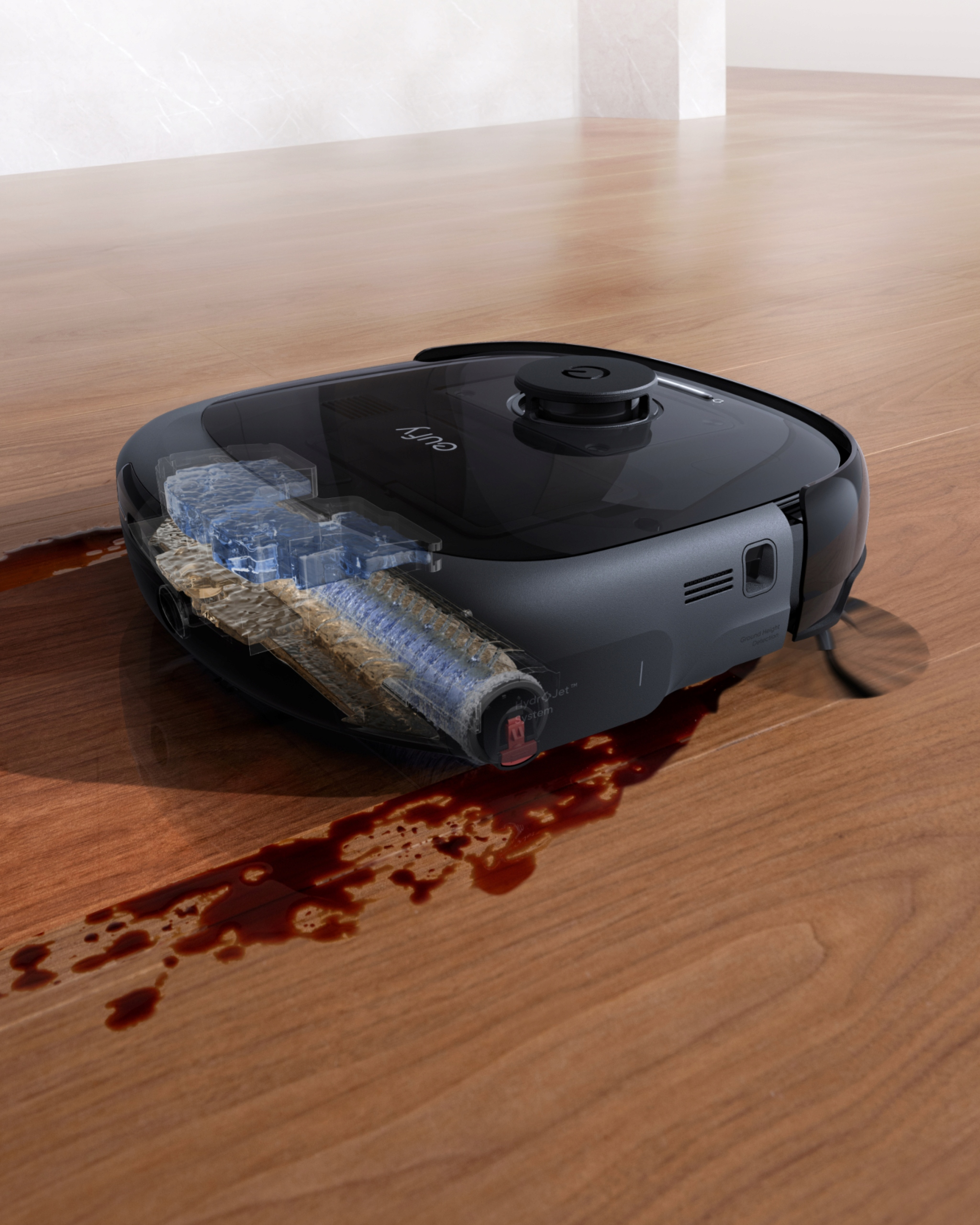 Czarny robot sprzątający czyszczący drewnianą podłogę z plamą po wodzie. Widać elementy wewnętrzne.