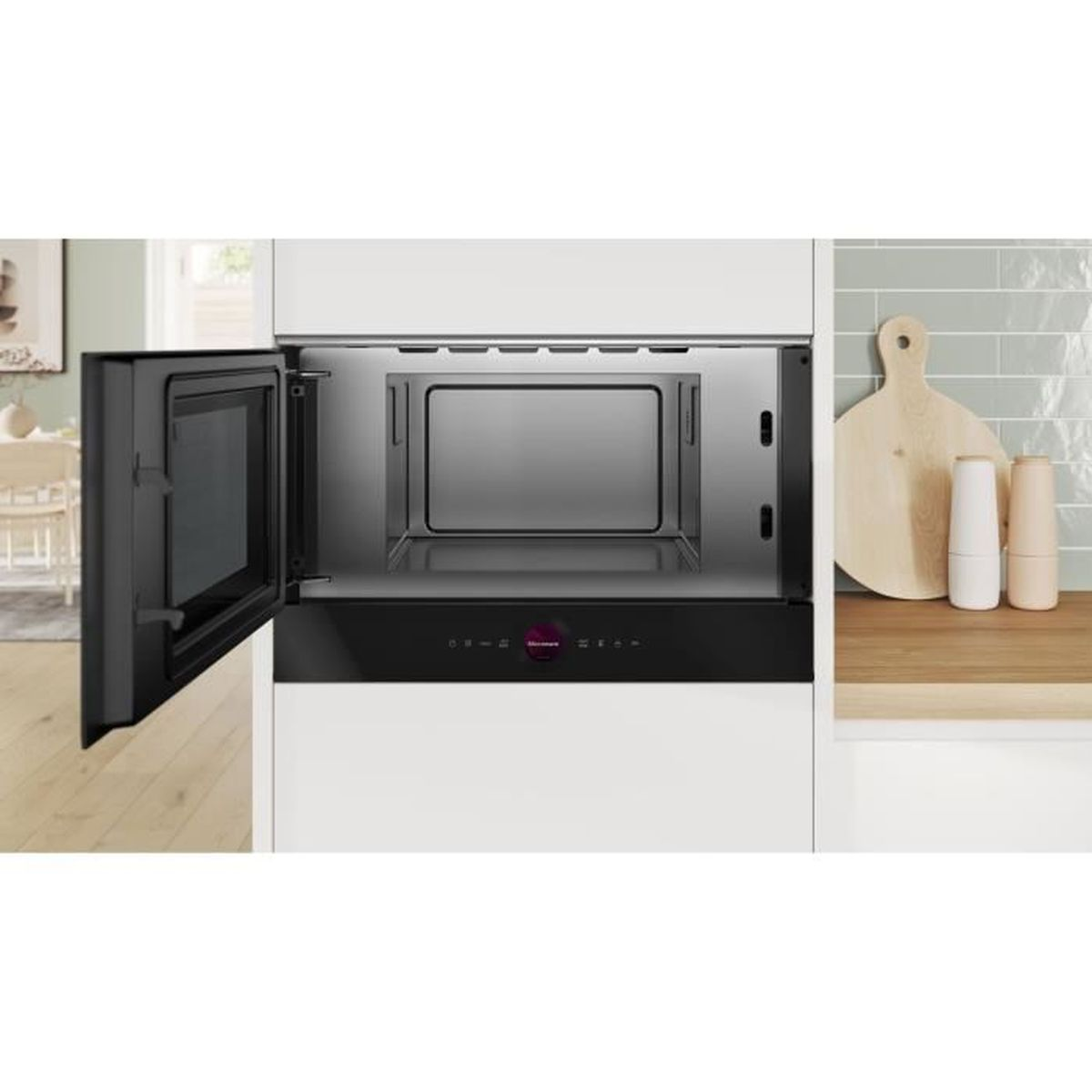 Primo piano di un forno a microonde, integrato in un mobile bianco. La porta è aperta.
