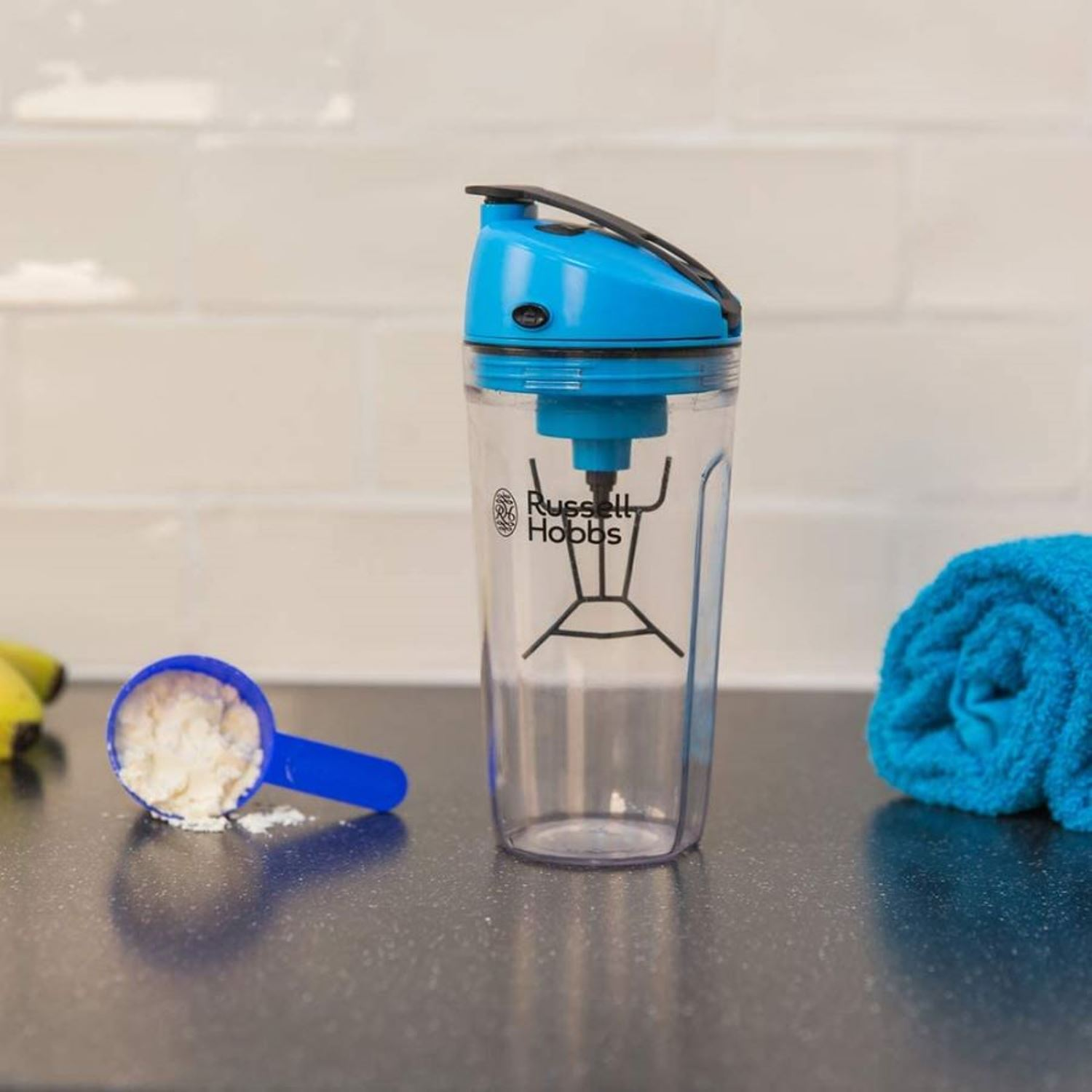 Russell Hobbs blender. Mavi ve şeffaf plastik, protein tozu ve masada mavi bir kaşık.