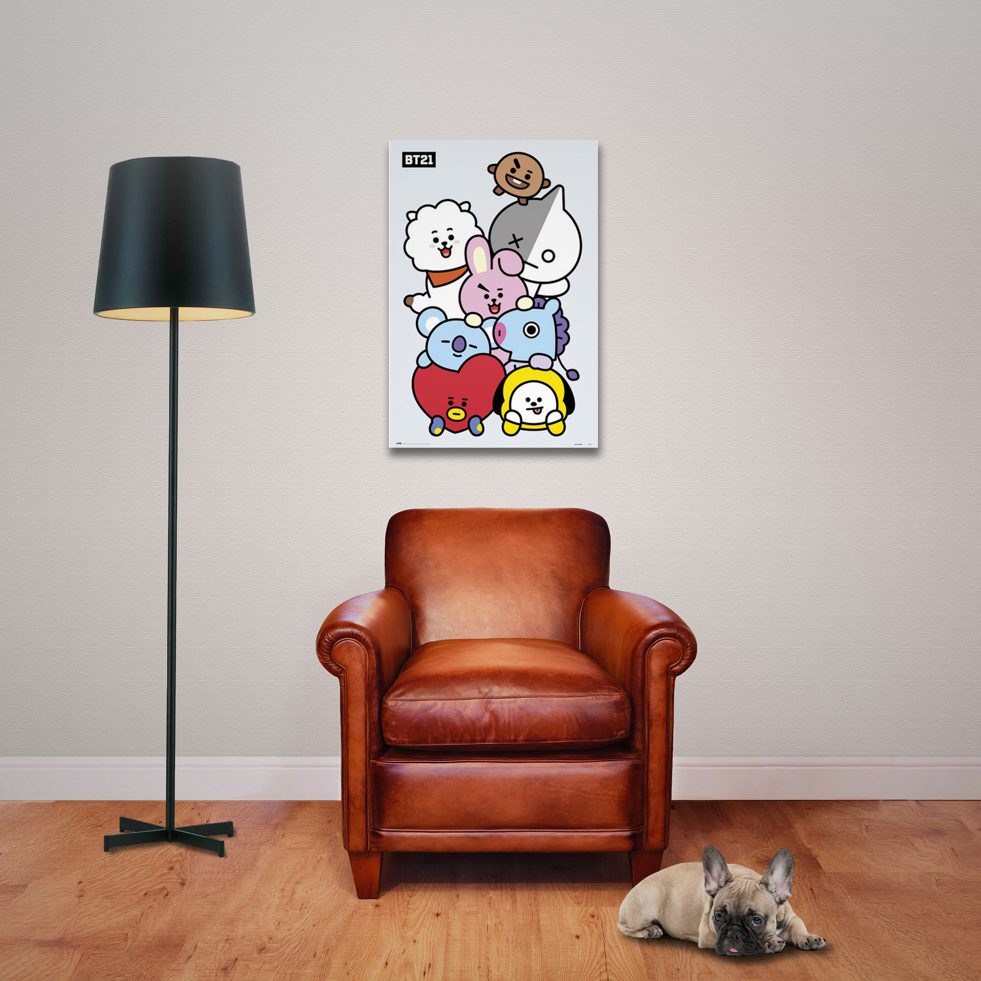 Ein Poster mit BT21-Charakteren an einer weißen Wand, ein Ledersofa und ein Hund liegt.