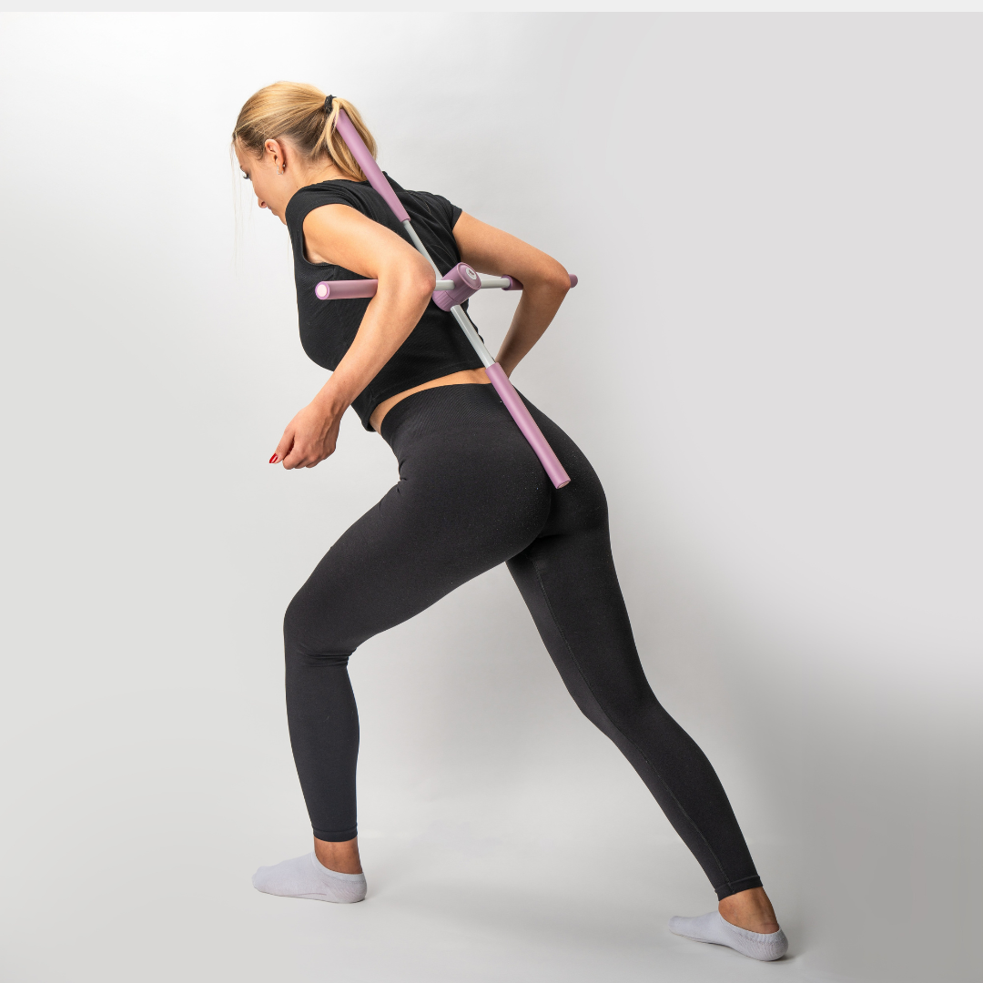 Eine Frau in schwarzer Leggings und einem schwarzen Hemd, die ein Haltungskorrekturgerät verwendet.