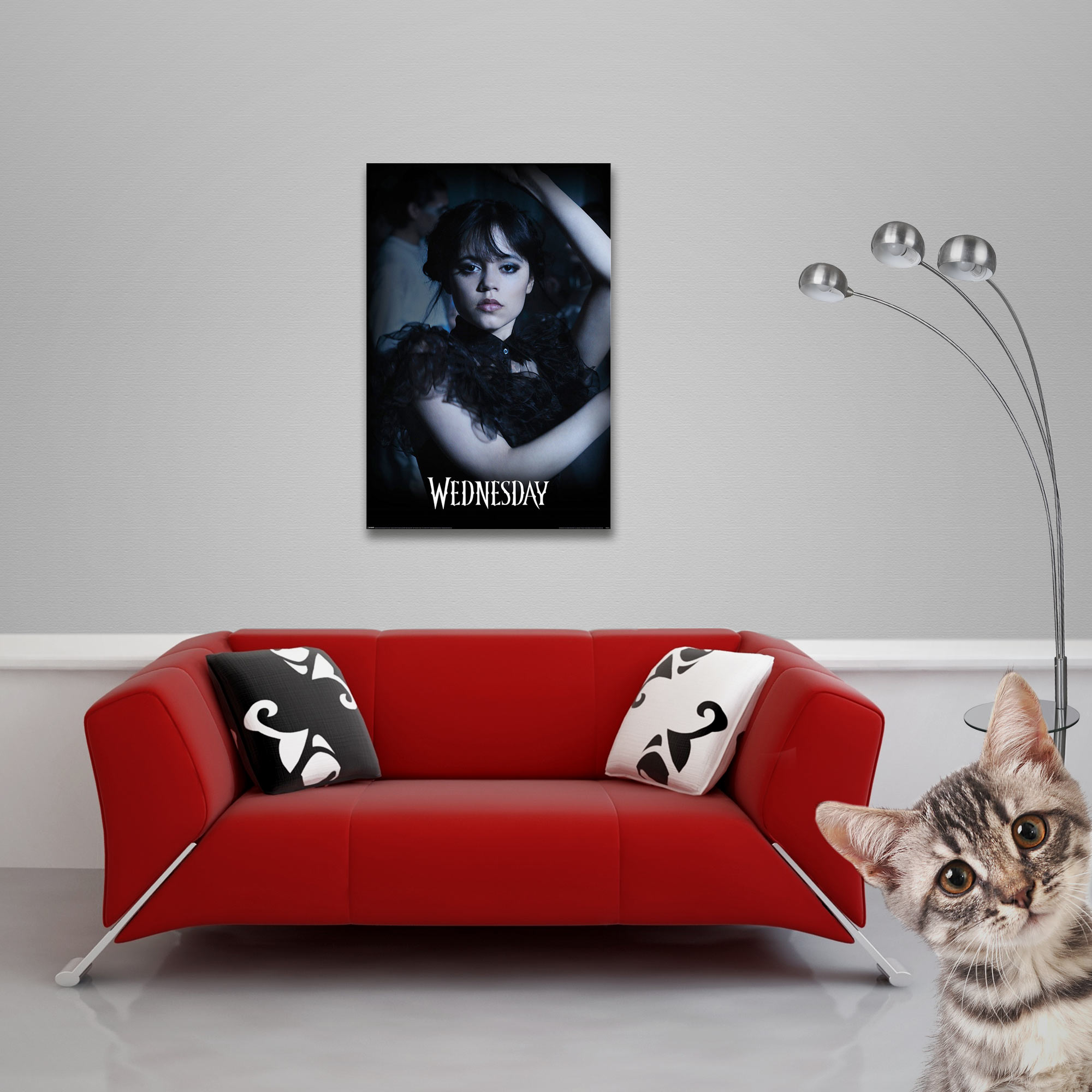 Poster von Jenna Ortega in schwarzem Kleid, rotes Sofa, Katze rechts.