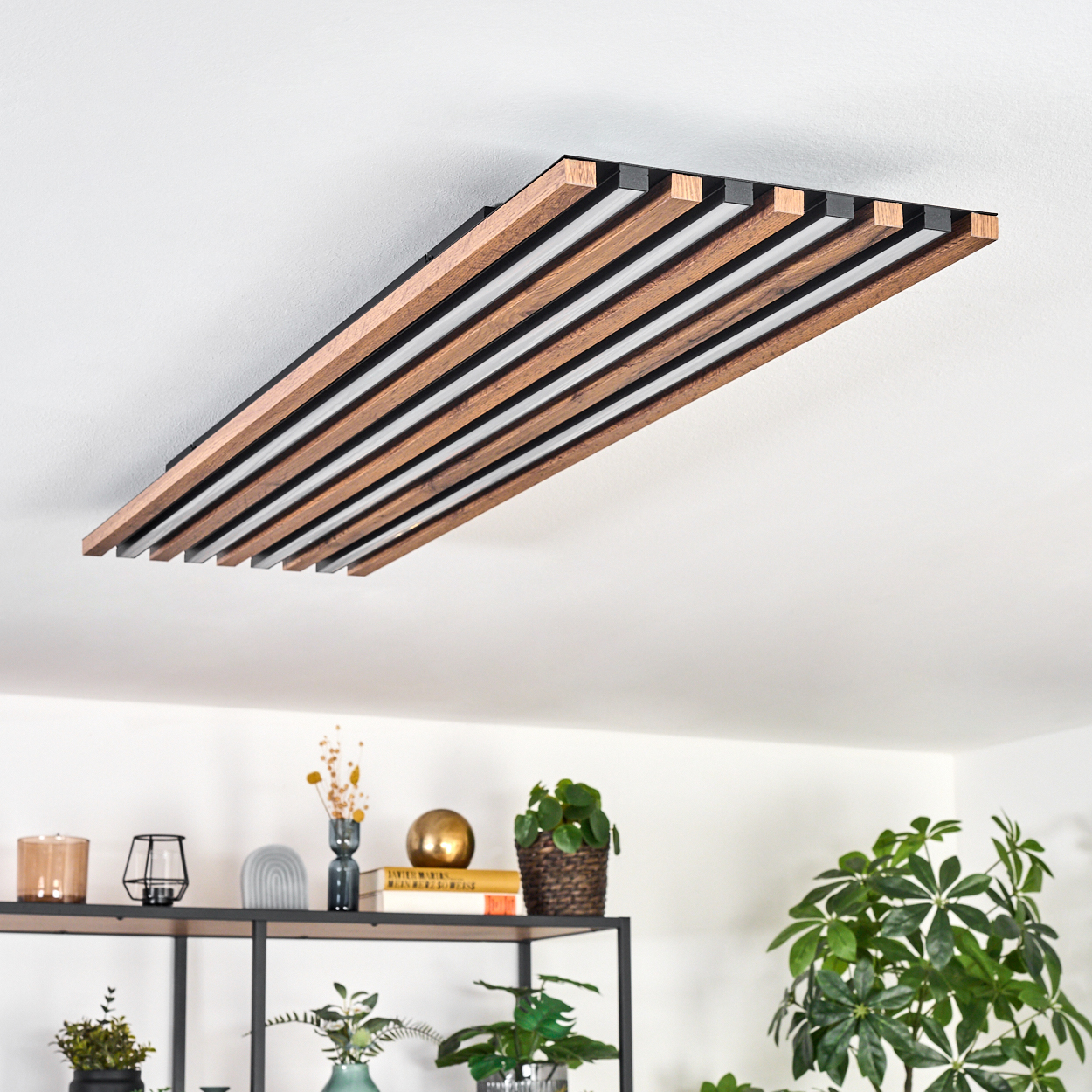 Eine moderne Deckenleuchte mit Holz- und schwarzen Paneelen. Die Leuchte ist an einer weißen Decke montiert.