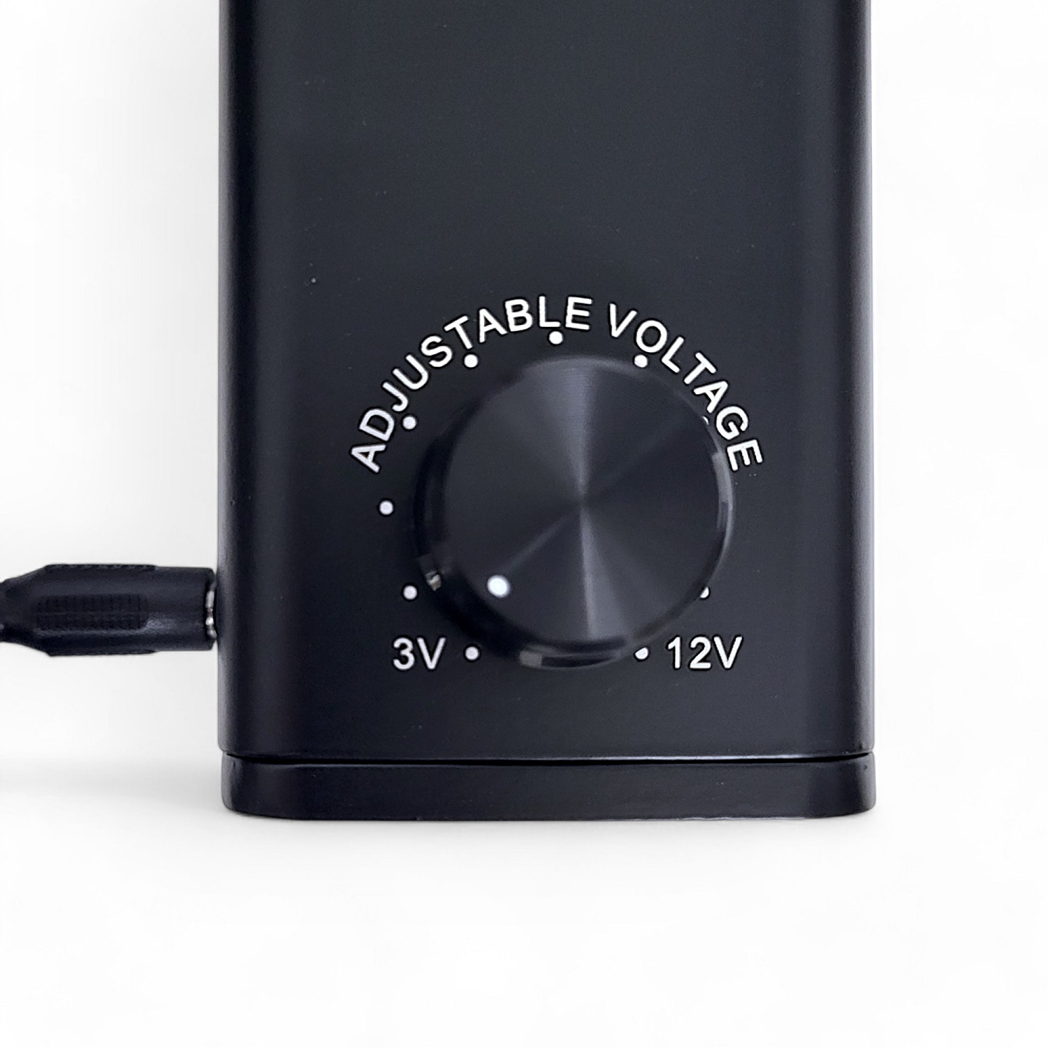 Schwarzes Gerät mit einstellbarem Spannungseinstellrad. Das Zifferblatt zeigt 3V und 12V an. Weißer Hintergrund.
