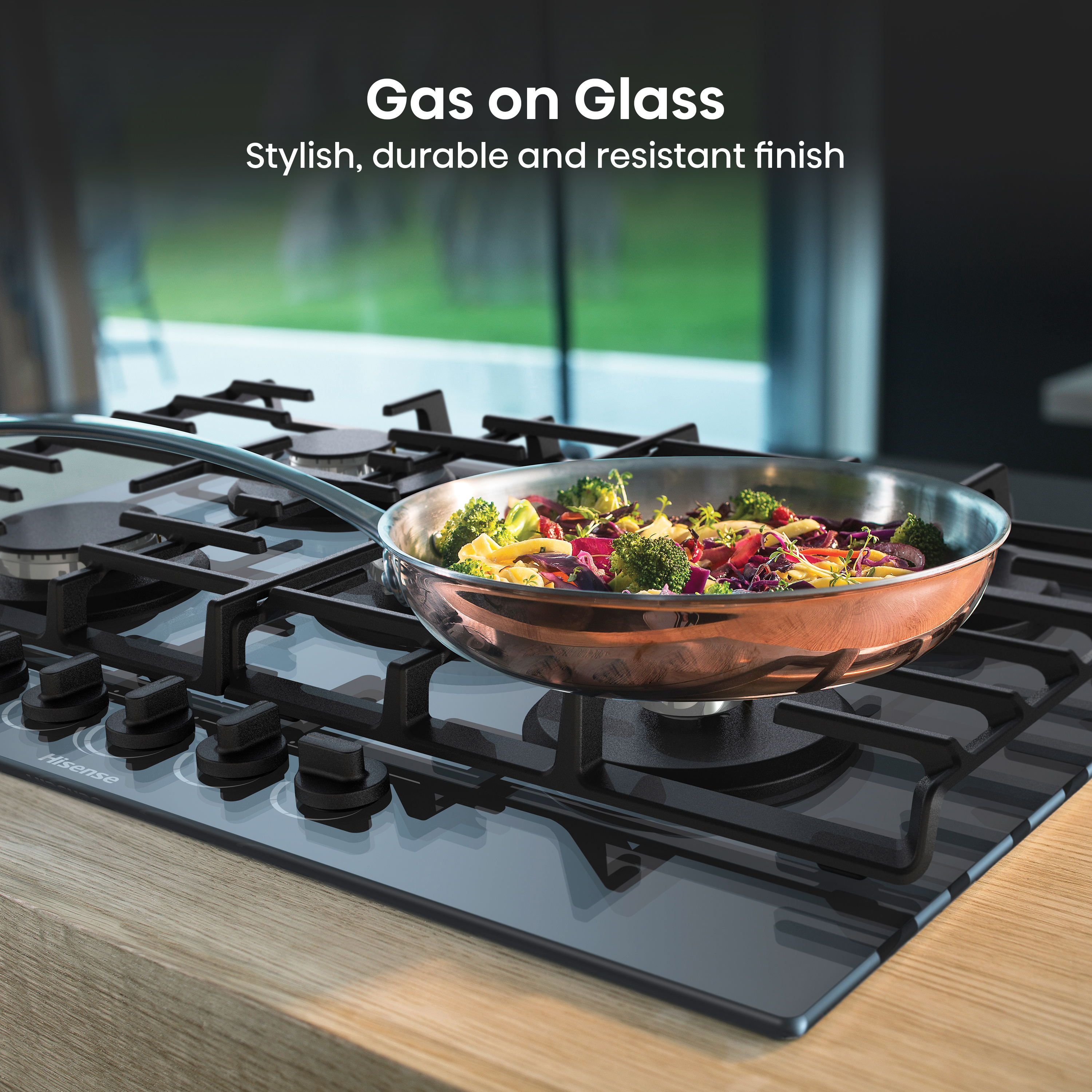 Encimera de gas negra con comida cocinándose en una sartén. Vista de la encimera y la cocina.