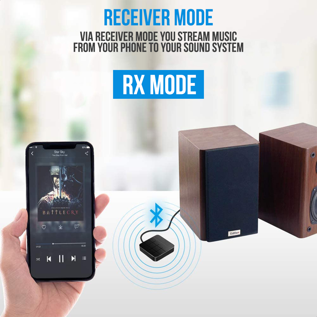 A hand holding a phone playing music, connected to a black audio adapter and two speakers.