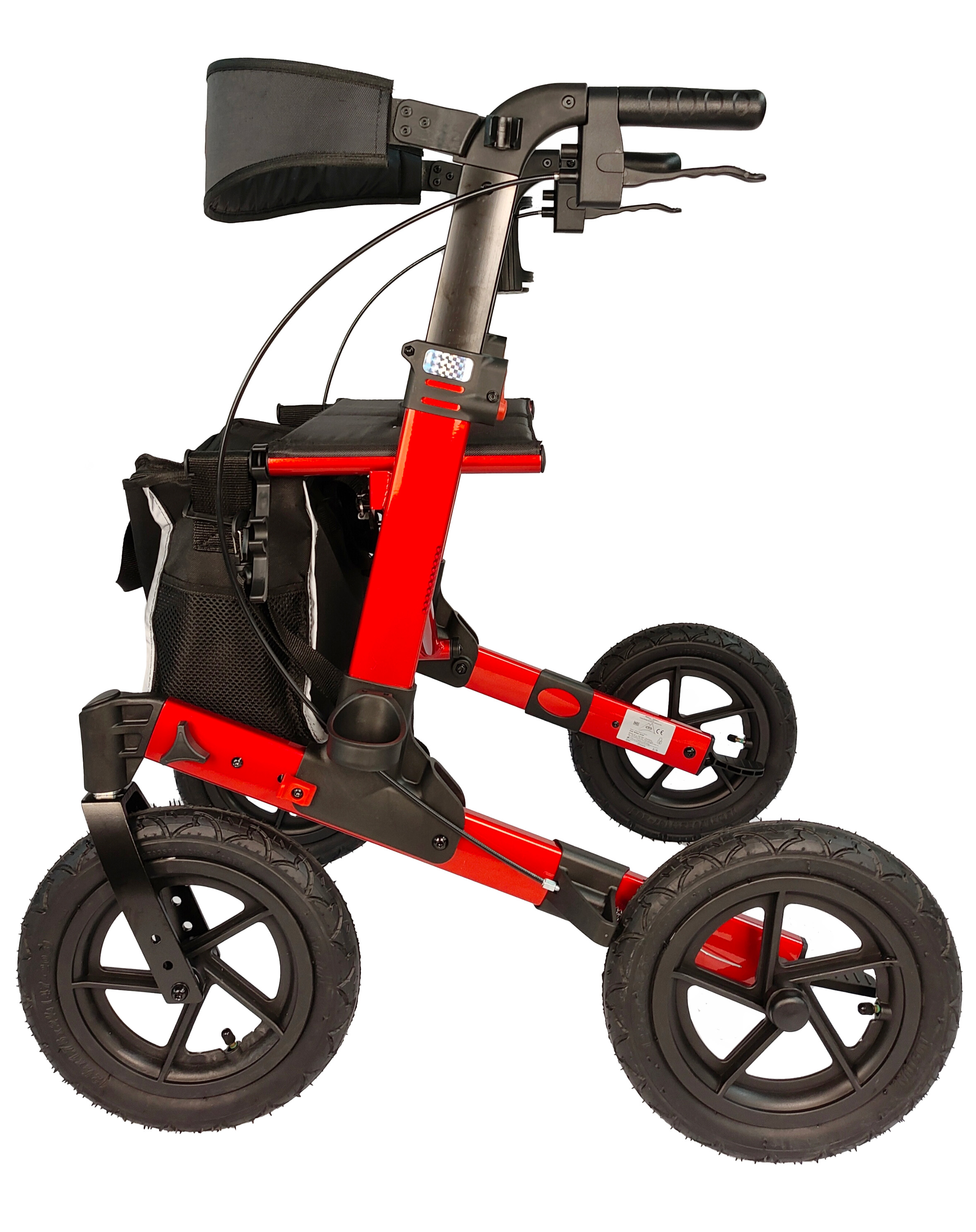 Ein roter Rollator mit vier schwarzen Rädern und einer schwarzen Tasche, von der Seite betrachtet, vor Weiß.