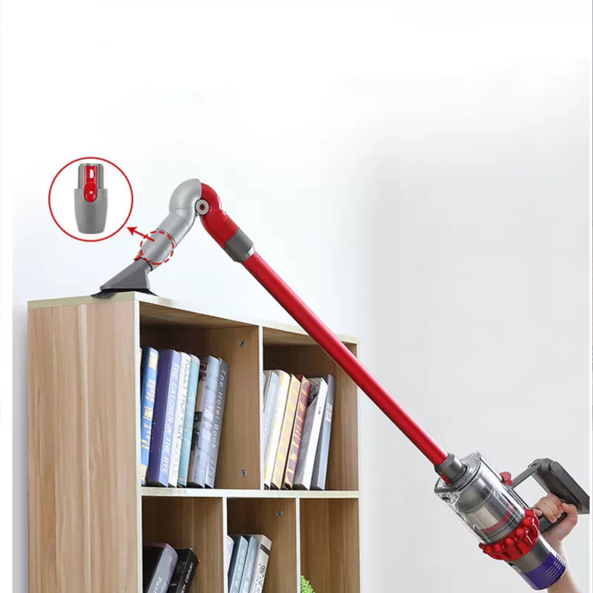 Eine Person benutzt einen Staubsauger, um ein Bücherregal zu reinigen. Der Staubsauger ist rot und grau.
