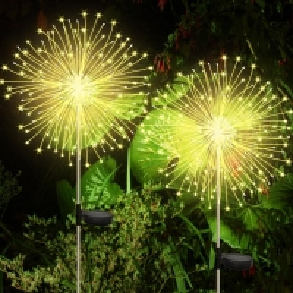 Nahaufnahme von zwei Solarleuchten im Freien, die Feuerwerk ähneln, mit heller gelber Beleuchtung.