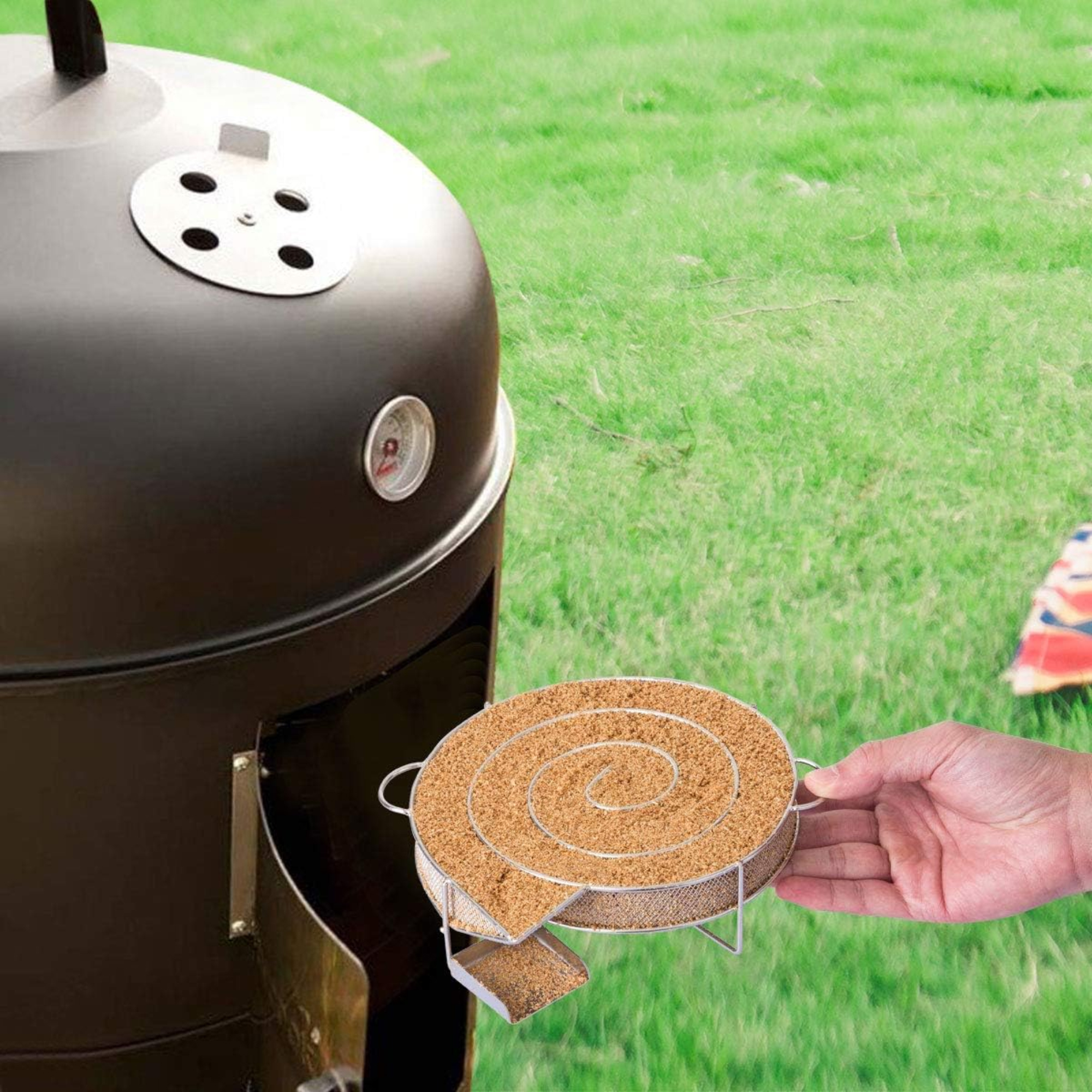 Ein Raucher mit einem spiralförmigen Holzchips-Halter. Eine Hand hält den Halter mit Holzchips, Grill und Gras im Hintergrund.