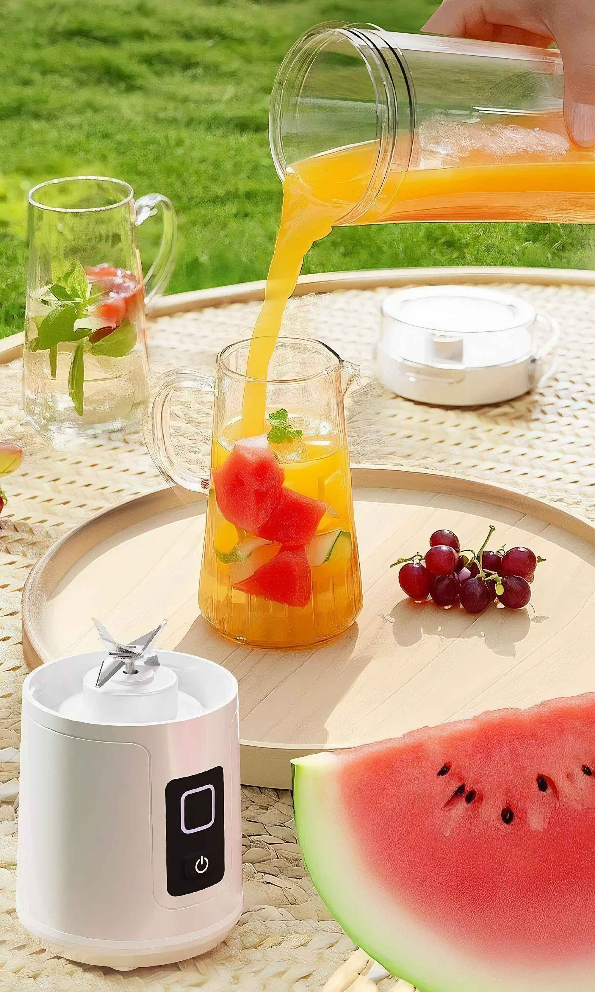 Eine Person gießt Orangensaft in ein Glas mit Wassermelonenstücken und einem Mixer auf einem Tisch.