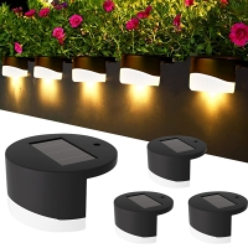 Solarbetriebene Außenleuchten an einer Wand in der Nähe von Blumen installiert. Die Leuchten sind schwarz und geben ein warmes Leuchten ab.