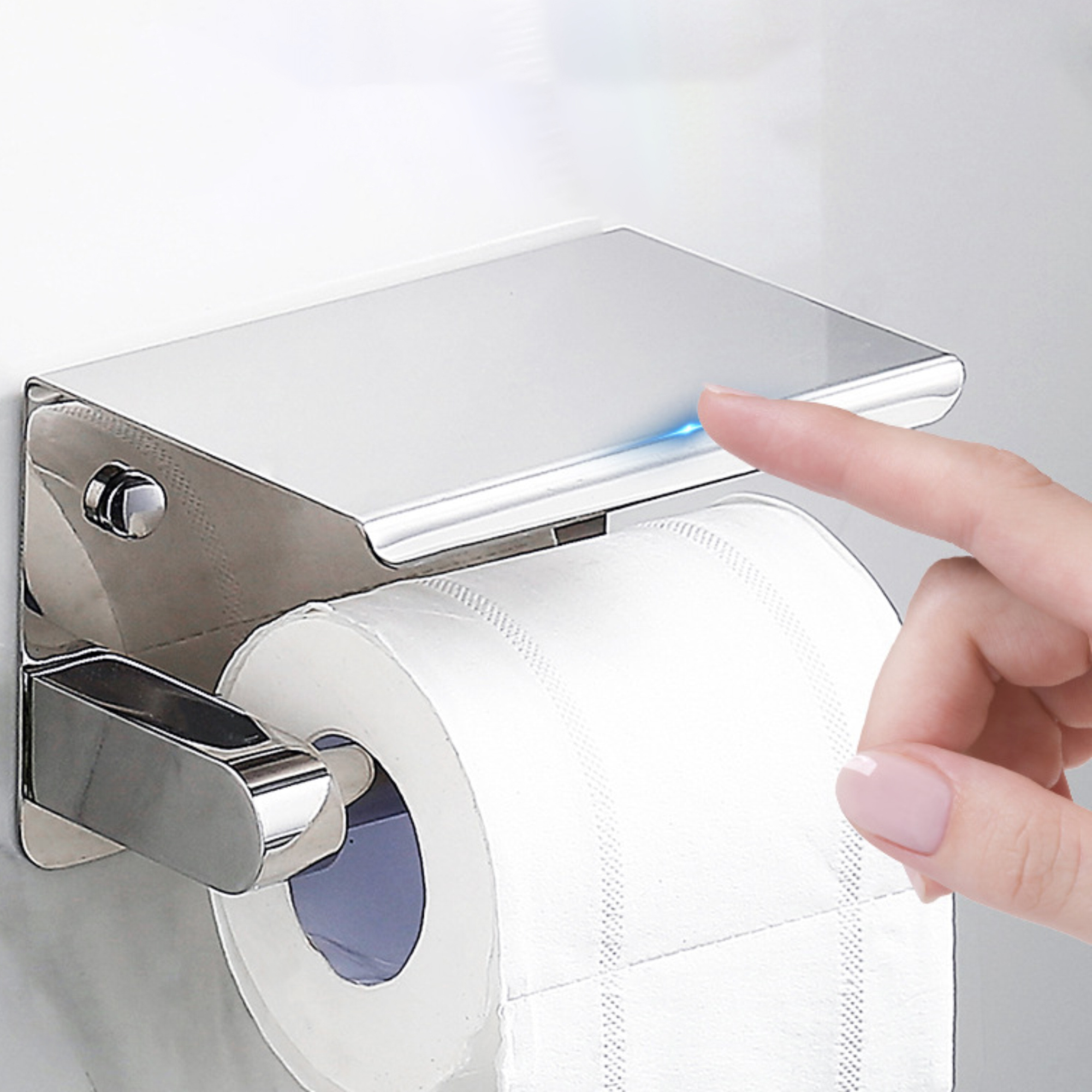 Verchromter Toilettenpapierhalter mit Rolle Papier. Ein Finger berührt die Oberseite, die leuchtet.