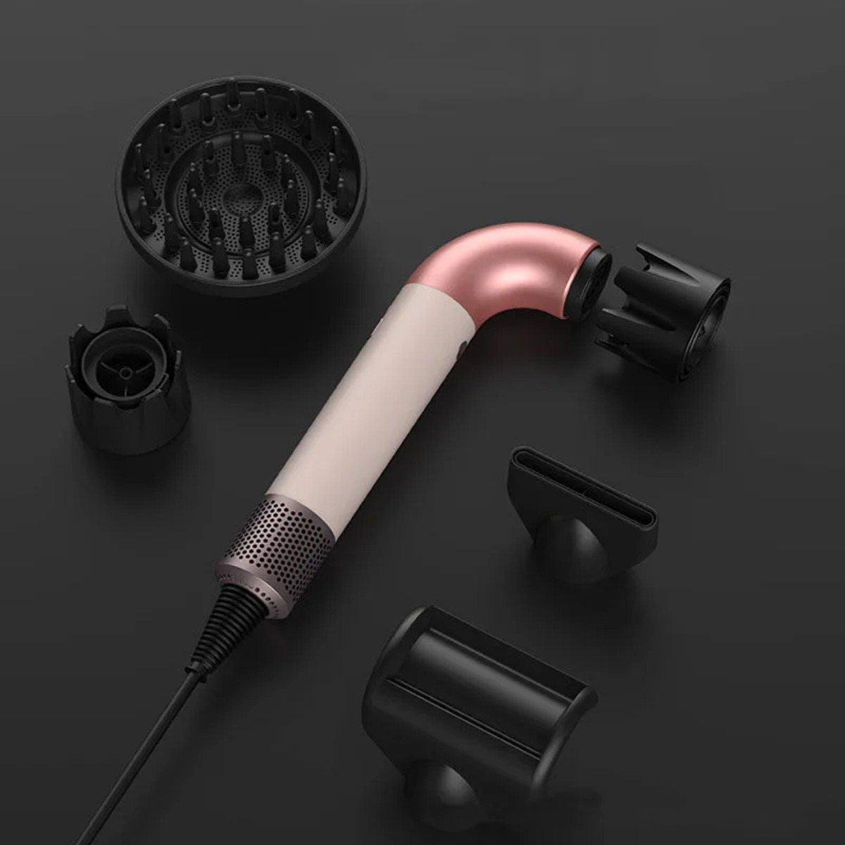 Secador de pelo con accesorios. Incluye varias boquillas y difusores sobre una superficie oscura.