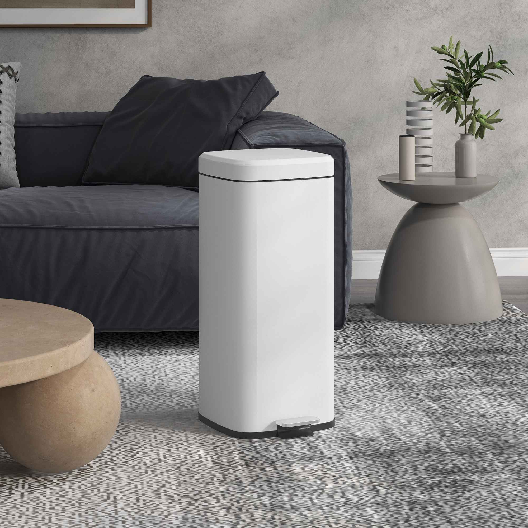 Weißer Mülleimer mit Pedal, auf einem gemusterten Teppich im Wohnzimmer.