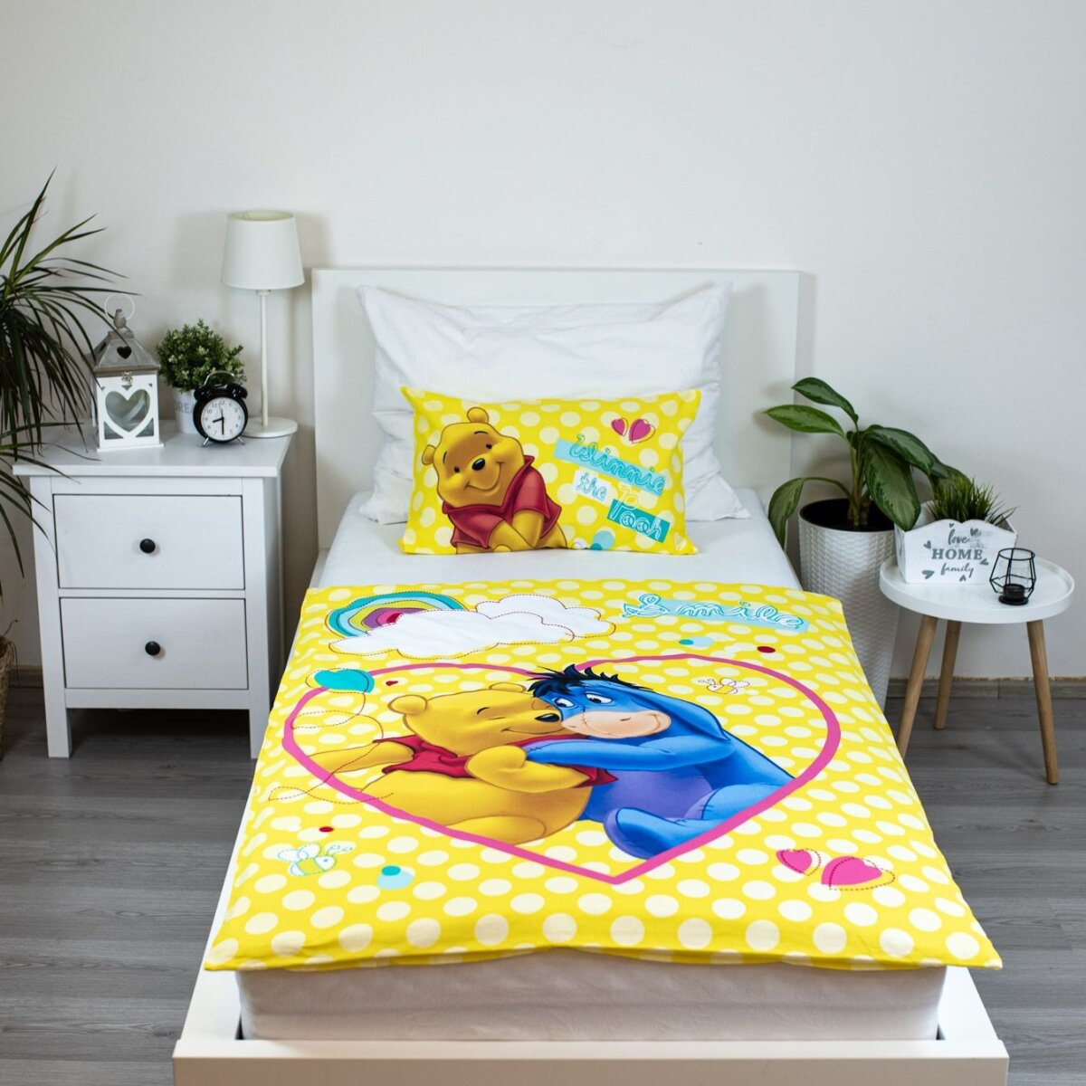Ein Bett mit Winnie-the-Pooh-Motiv, mit Pooh und Eeyore auf der Bettwäsche.