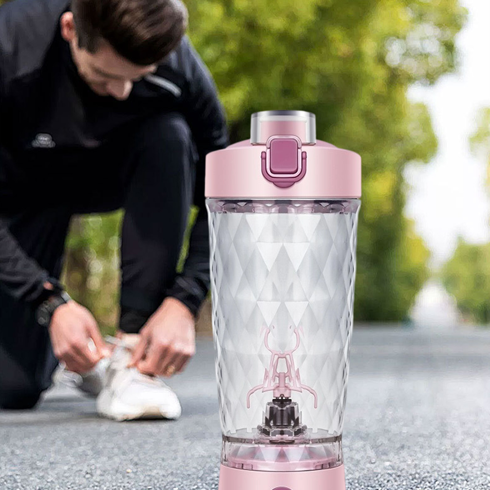 Eine Person bindet ihren Schuh in der Nähe einer pinken Shaker-Flasche mit Mixer.
