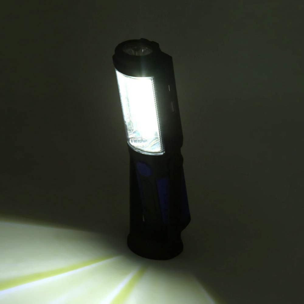 Eine schwarz-blaue Arbeitsleuchte, beleuchtet, scheint Licht auf eine dunkle Oberfläche. Die LED ist hell.