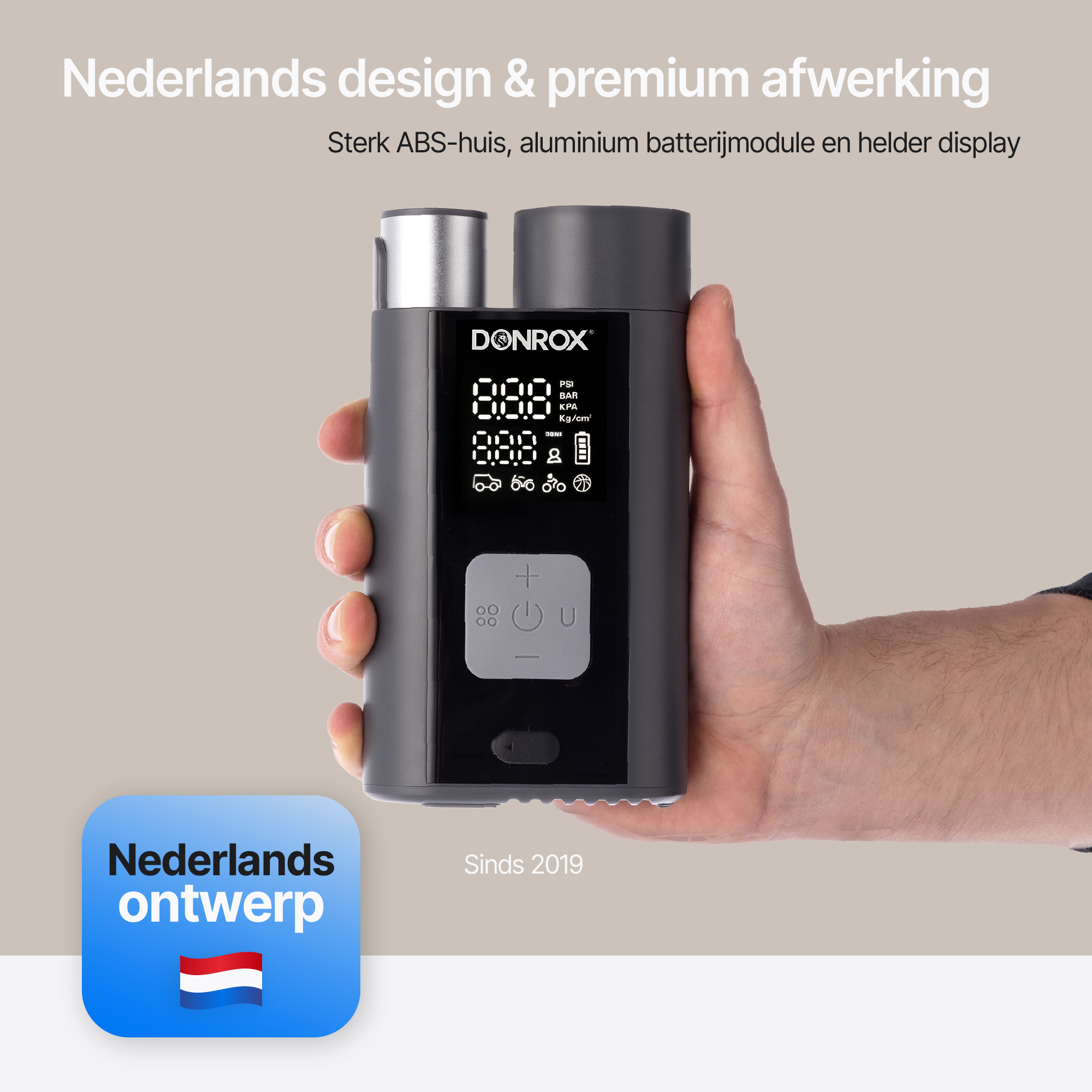 Hand holding a gray air compressor with display showing pressure. Text: 'Dutch design & premium finish'.