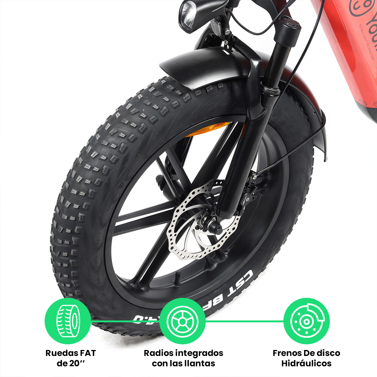 Primer plano de una rueda de bicicleta eléctrica con neumáticos anchos, frenos de disco y etiquetas en español.