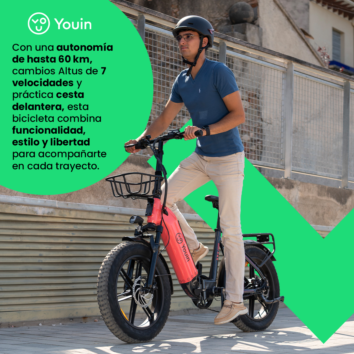 Una persona monta una bicicleta eléctrica roja en una calle de la ciudad. El logo Youin es visible.