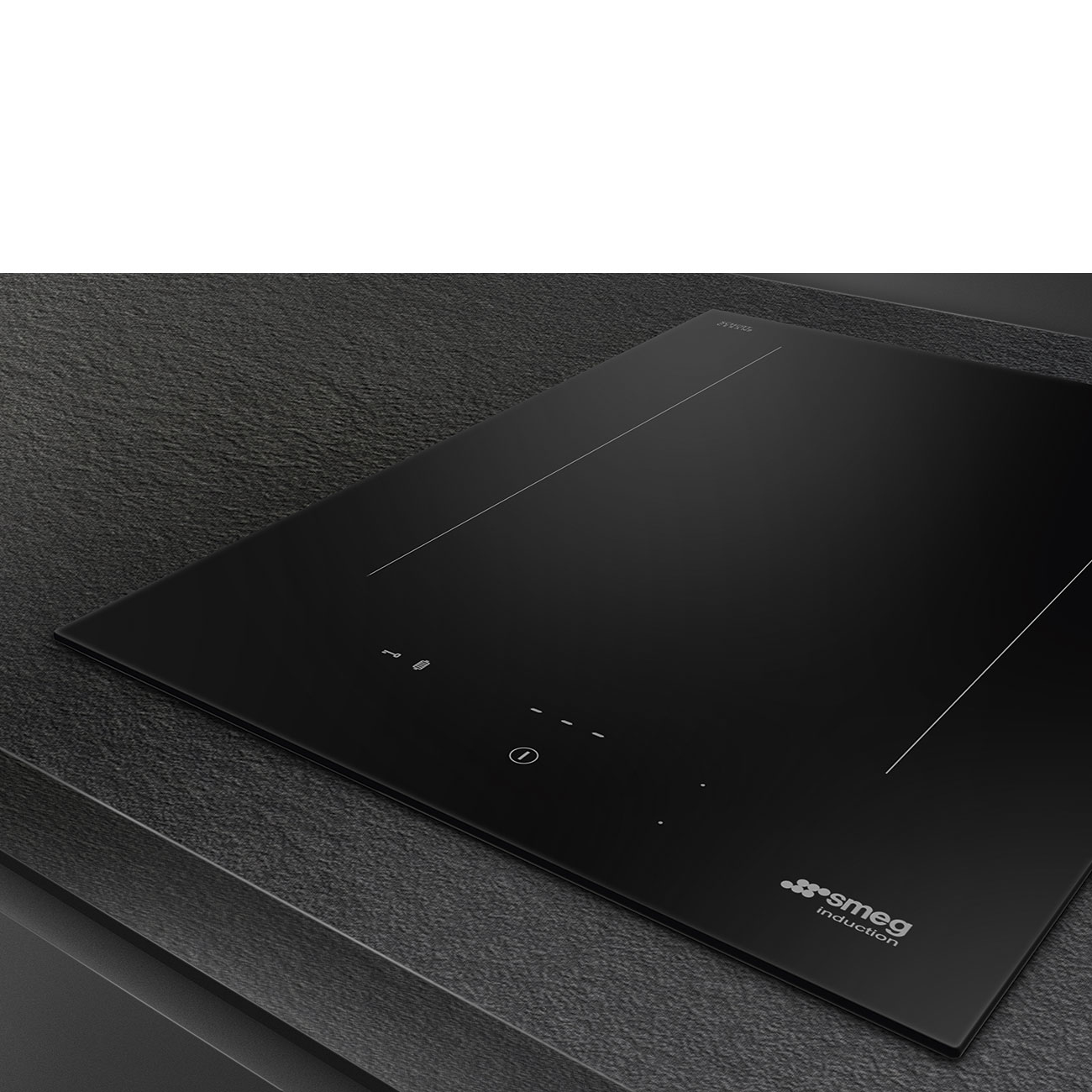 Un piano cottura a induzione nero su un piano scuro con il logo Smeg Induction visibile.