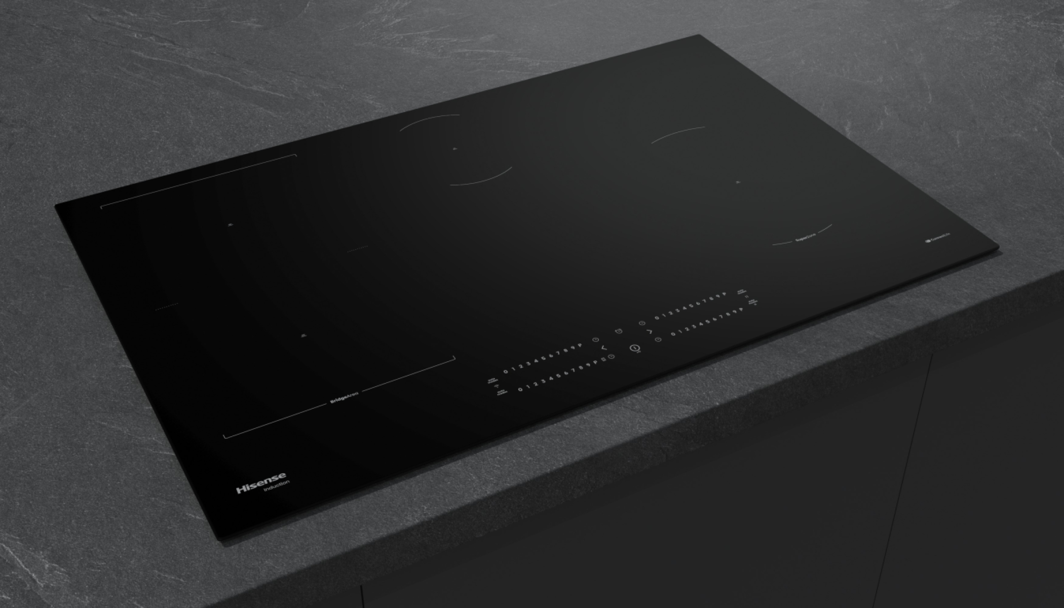 Piano cottura a induzione nero su un piano di lavoro grigio scuro. Con comandi digitali e 4 zone.