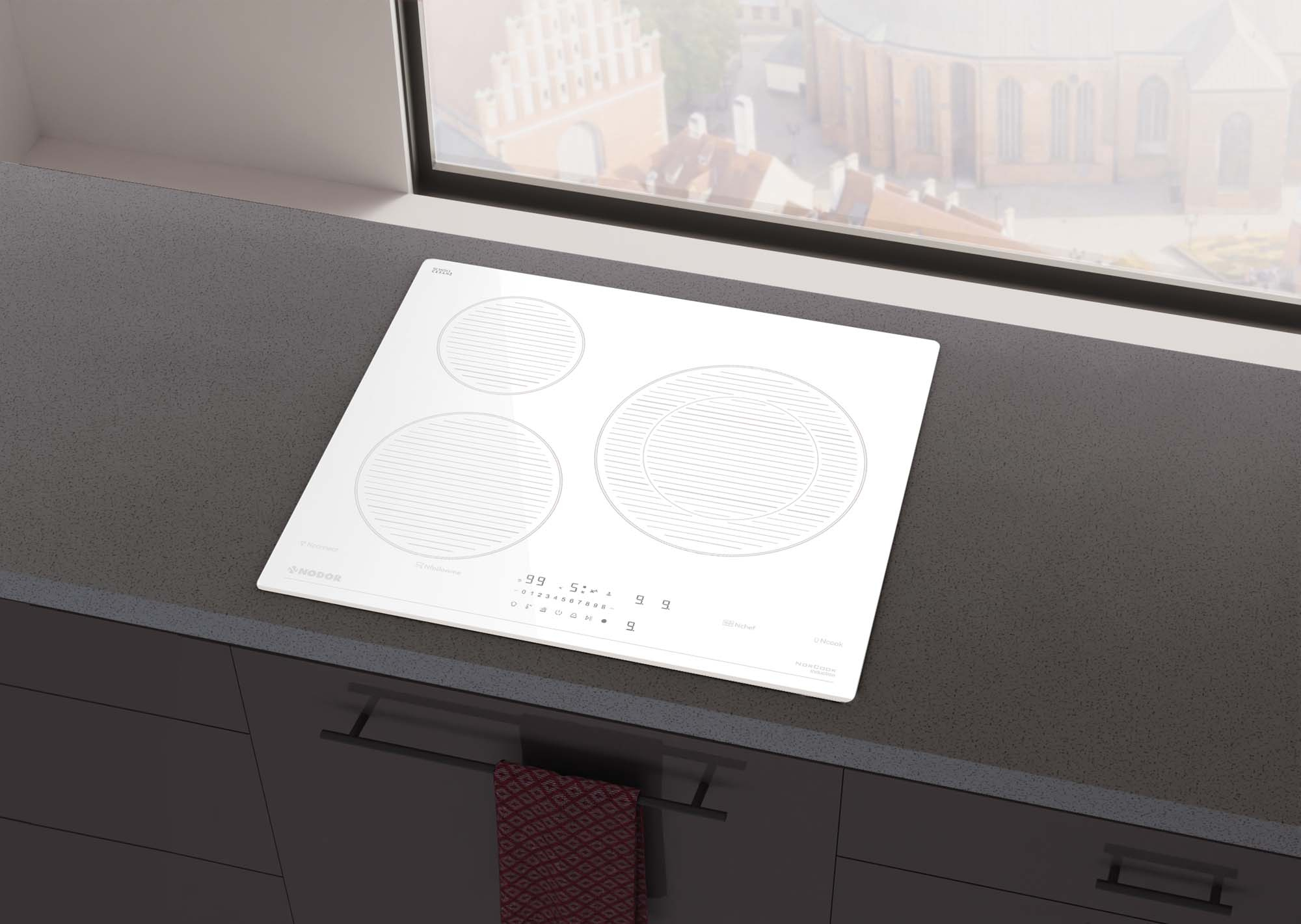Placa de inducción blanca con tres zonas de cocción. Sobre encimera gris, cerca de una ventana. Ambiente de cocina moderno.