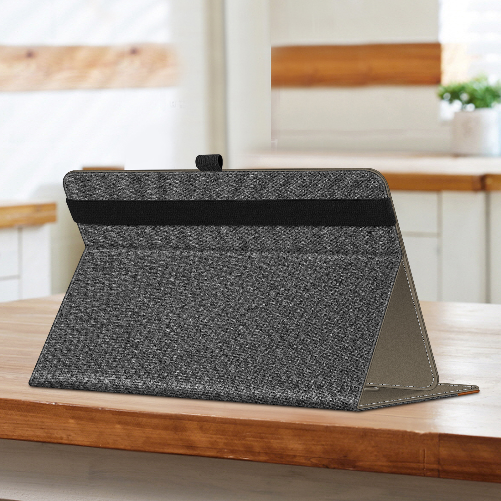 Tablethülle, grauer Stoff, auf einem Holztisch geöffnet, schwarzes Gummiband.