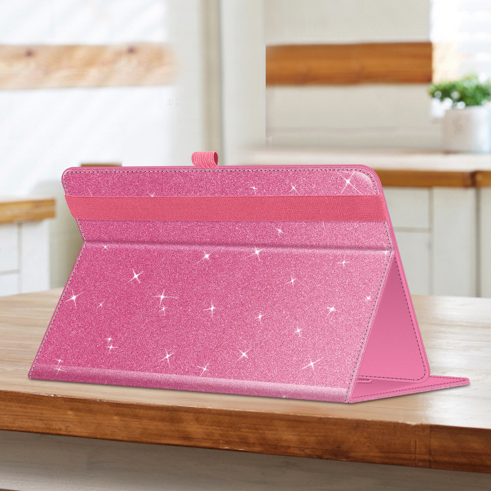 Offene rosa Glitzer-Tablethülle auf einem Holztisch, mit einem rosa Gummiband.