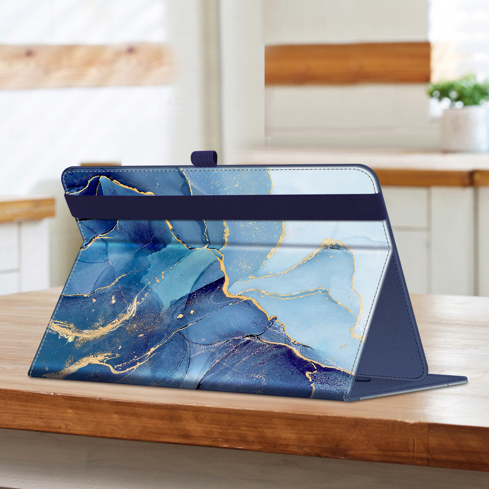 Eine Tablethülle auf einem Holztisch, offen, mit blauem und goldenem Marmordesign. Sie steht aufrecht.