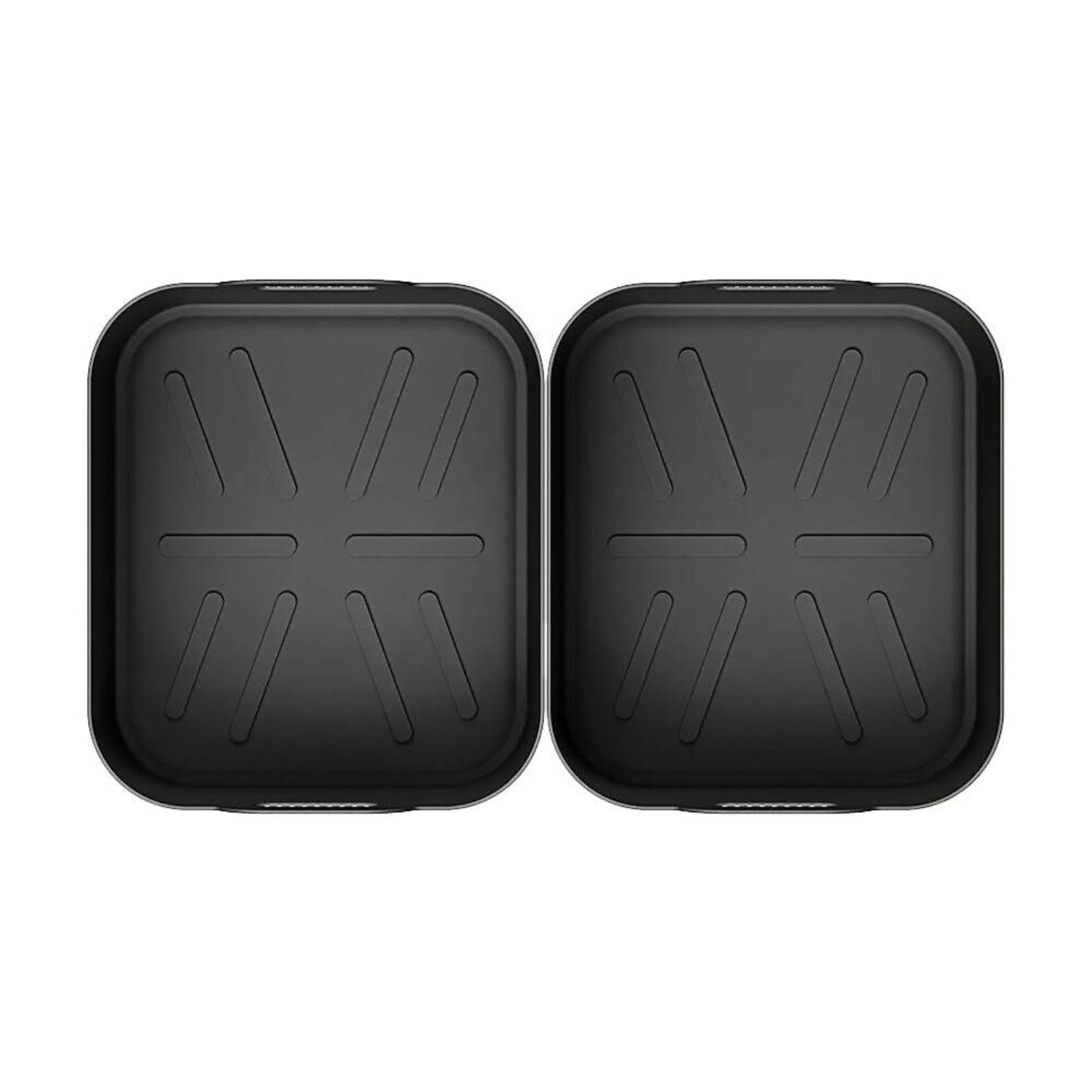 Zwei schwarze Airfryer-Tabletts mit strukturierten Böden werden nebeneinander vor einem weißen Hintergrund gezeigt. Sie scheinen unbenutzt zu sein.