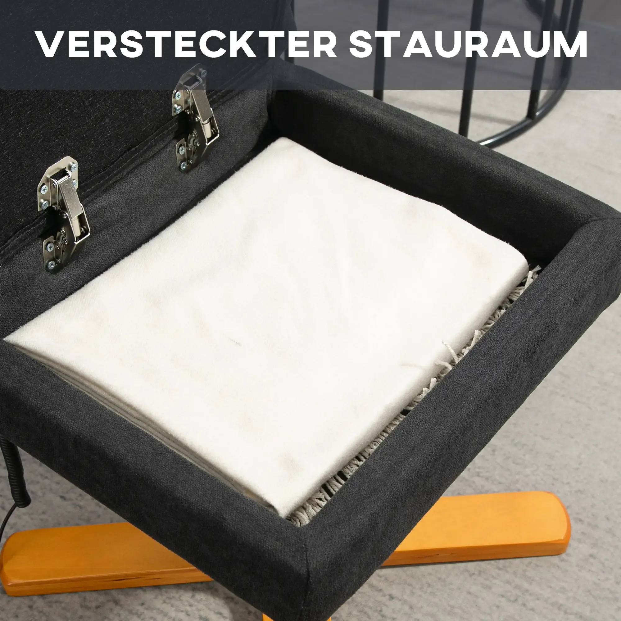 Offener schwarzer Stauraum unter einem Stuhlsitz mit einem weißen Tuch darin.