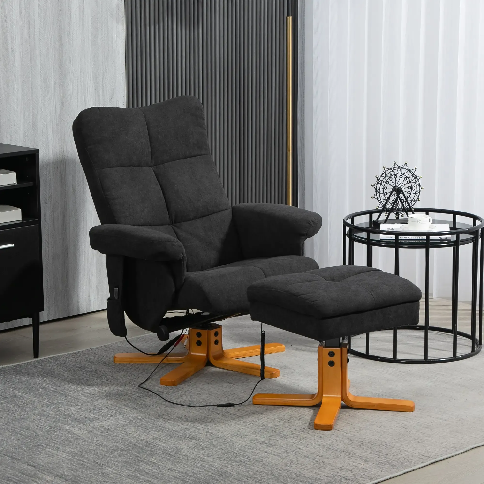 Schwarzer Relaxsessel und Hocker in einem modernen Wohnzimmer, mit Beistelltisch und Deko.