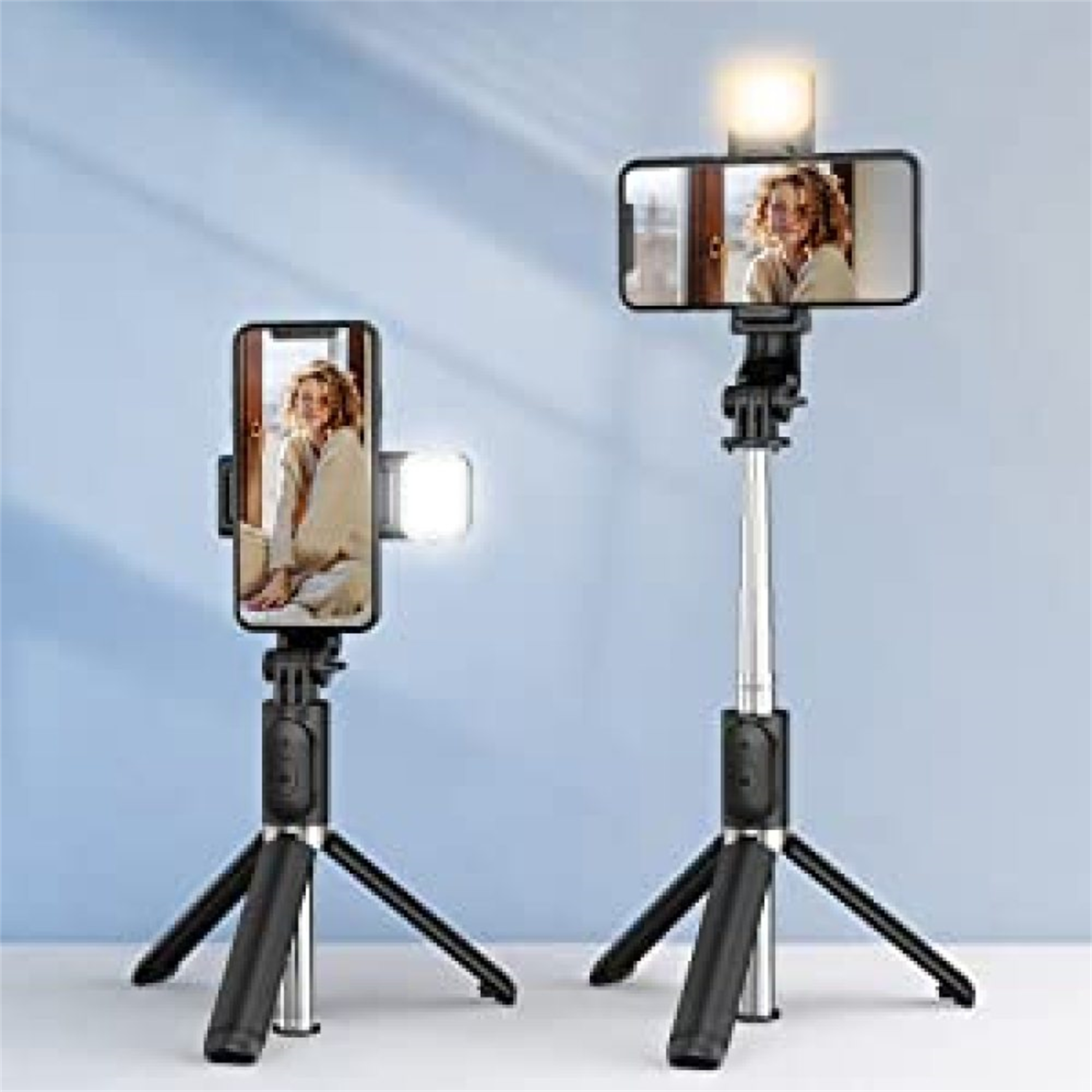 Zwei Selfie-Sticks mit befestigten Telefonen, einer mit Licht. Die Sticks haben Stative und Lichter, auf hellem Hintergrund.