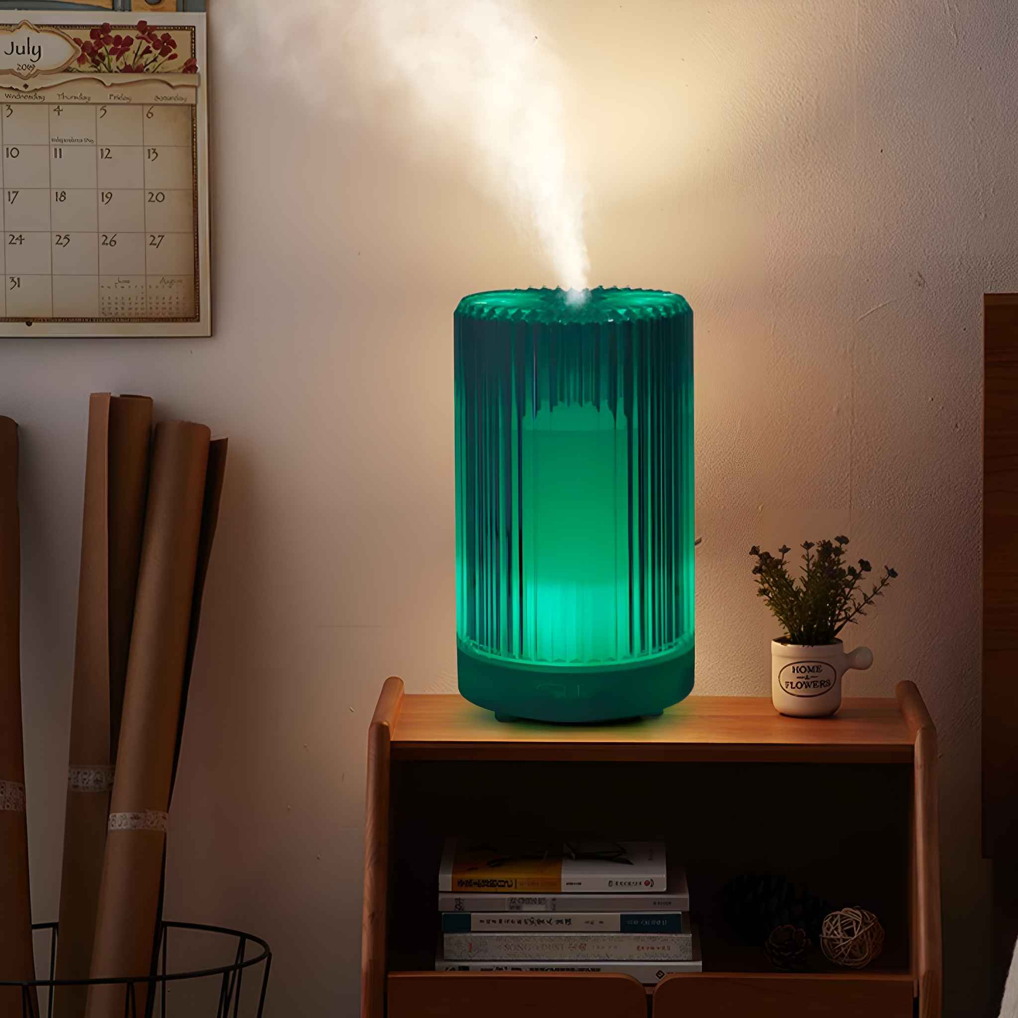 Ein Aromadiffusor mit grünem Licht, auf einem Nachttisch mit Kalender und Büchern.