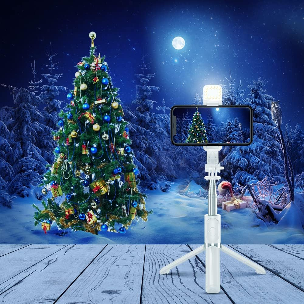 Weihnachtsszene mit geschmücktem Baum, Telefon auf Selfie-Stick und verschneiter Landschaft.