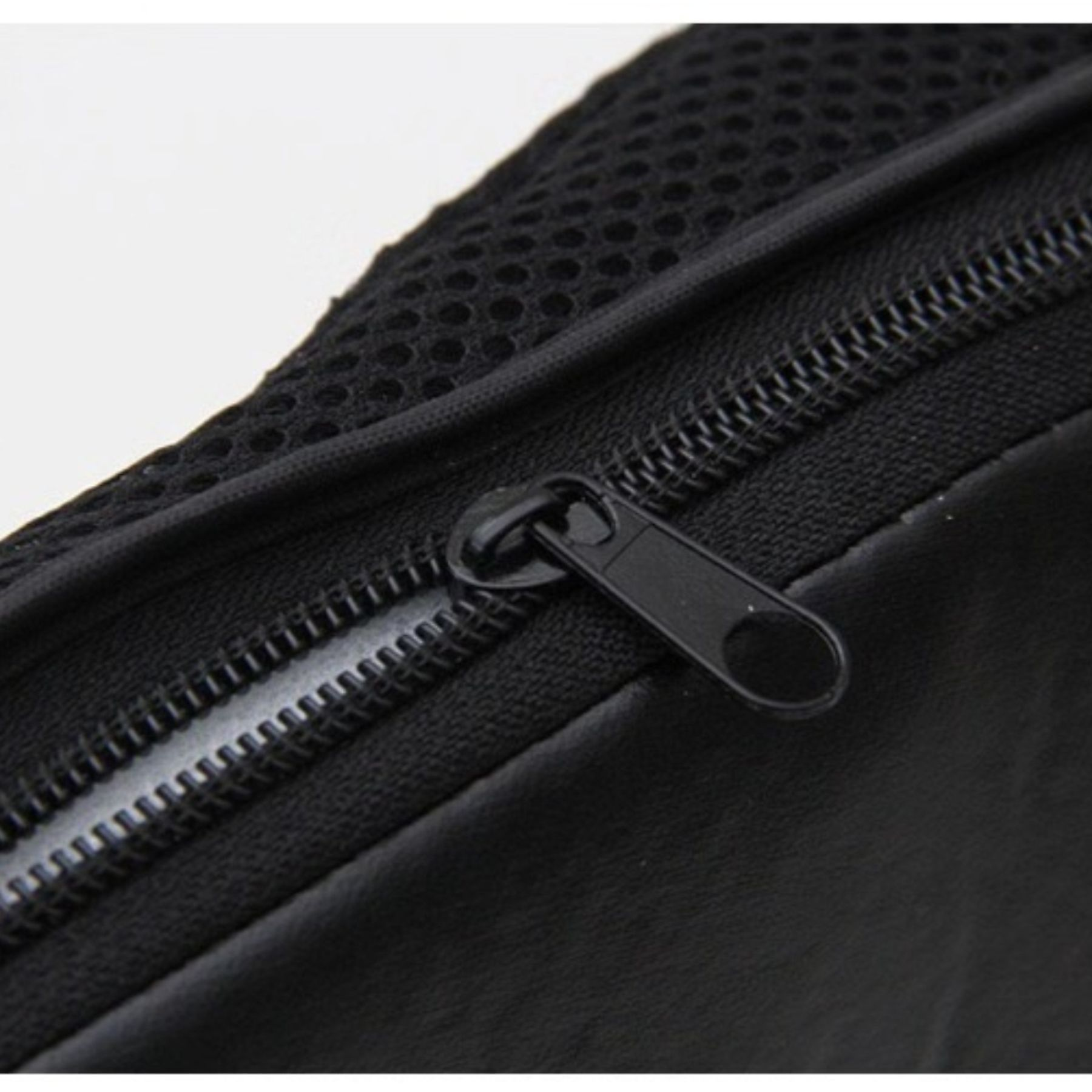 Nahaufnahme einer schwarzen Tasche mit Reißverschluss. Mesh-Material oben. Der Reißverschluss ist geschlossen.