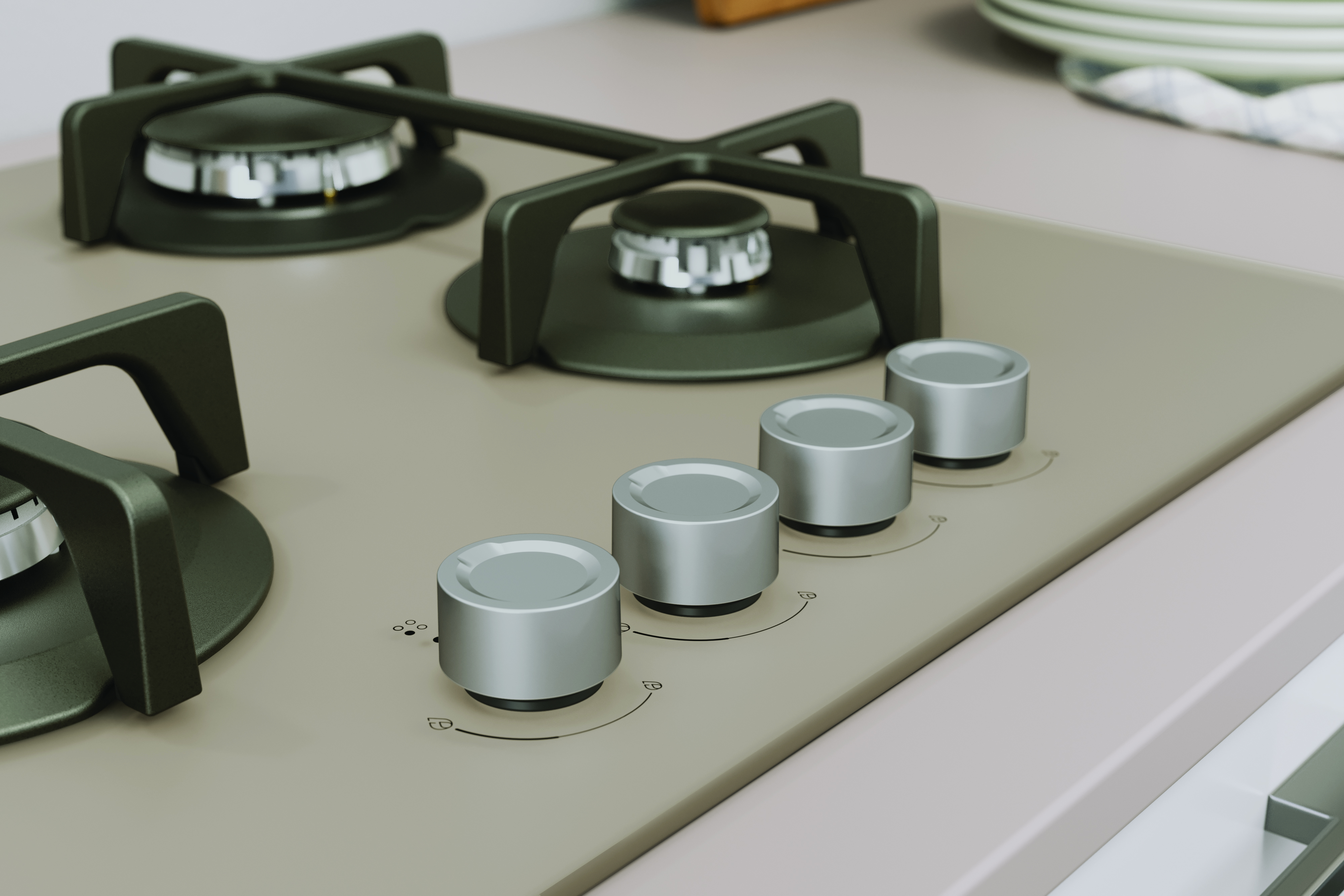 Zbliżenie na płytę gazową z czterema pokrętłami. Płyta jest piaskowa z ciemnozielonymi akcentami.