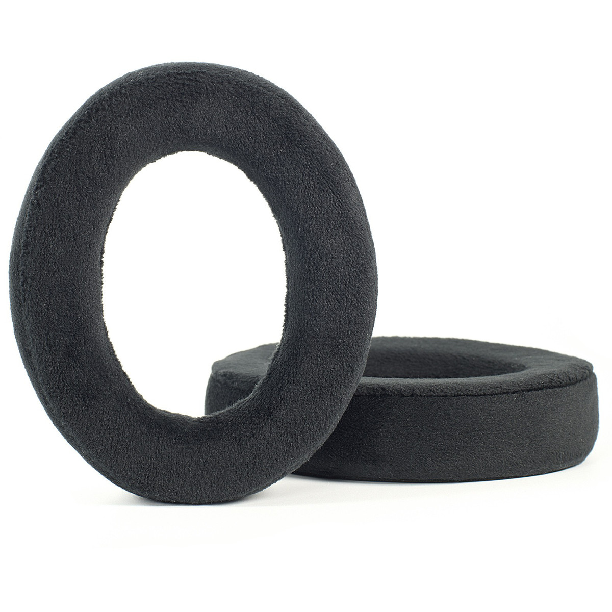 Due cuscinetti auricolari neri e soffici per cuffie. Sono rotondi e spessi, realizzati in materiale morbido.