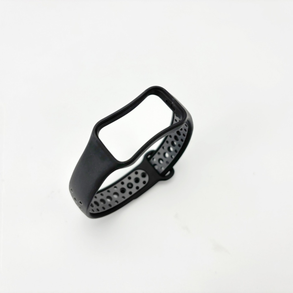 Ein schwarzes Uhrenarmband mit Löchern liegt auf einer weißen Oberfläche. Das Armband ist gebogen und zeigt einen Verschlussbereich.