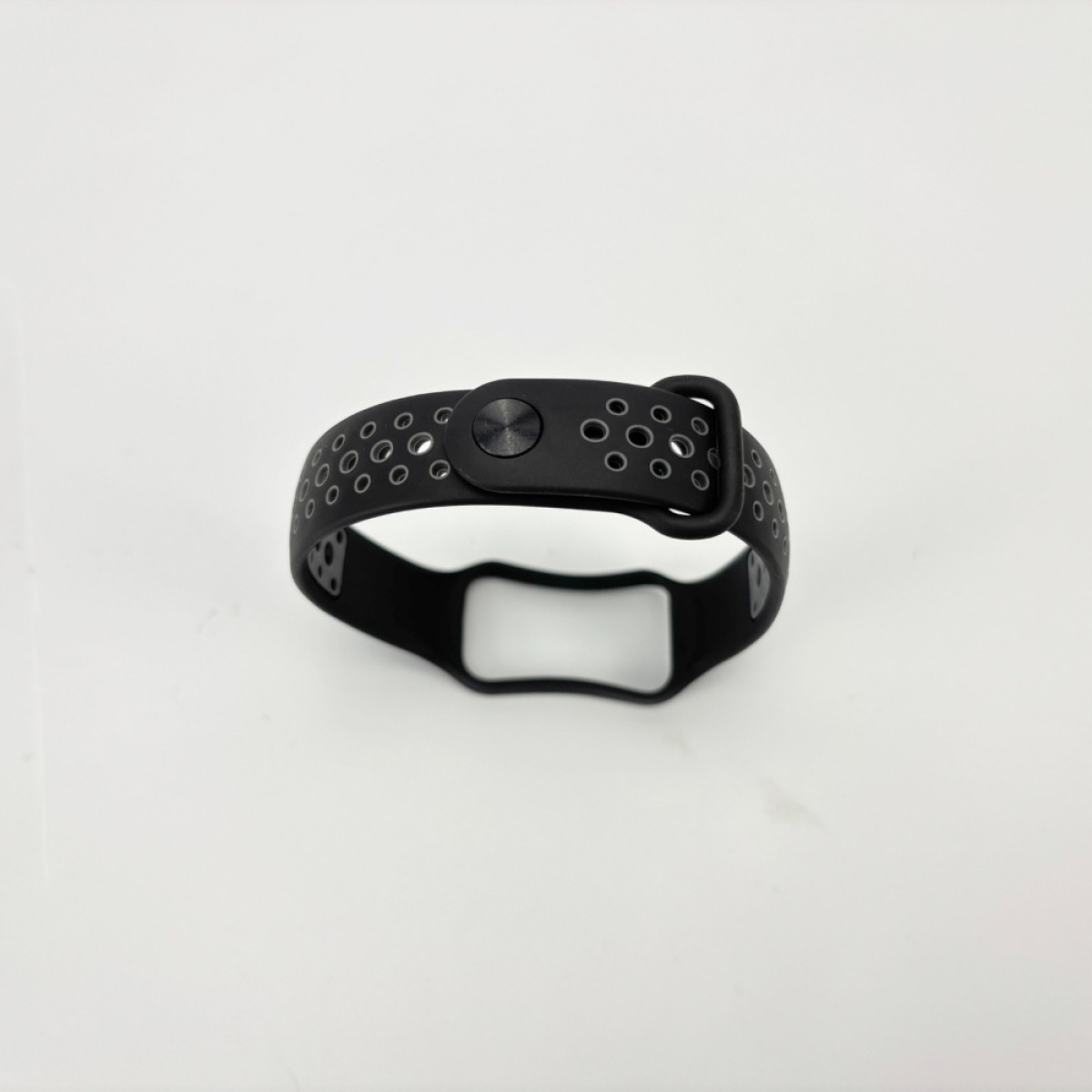 Schwarzes Uhrenarmband mit mehreren Löchern. Eine Schnalle auf der rechten Seite. Weißer Hintergrund.
